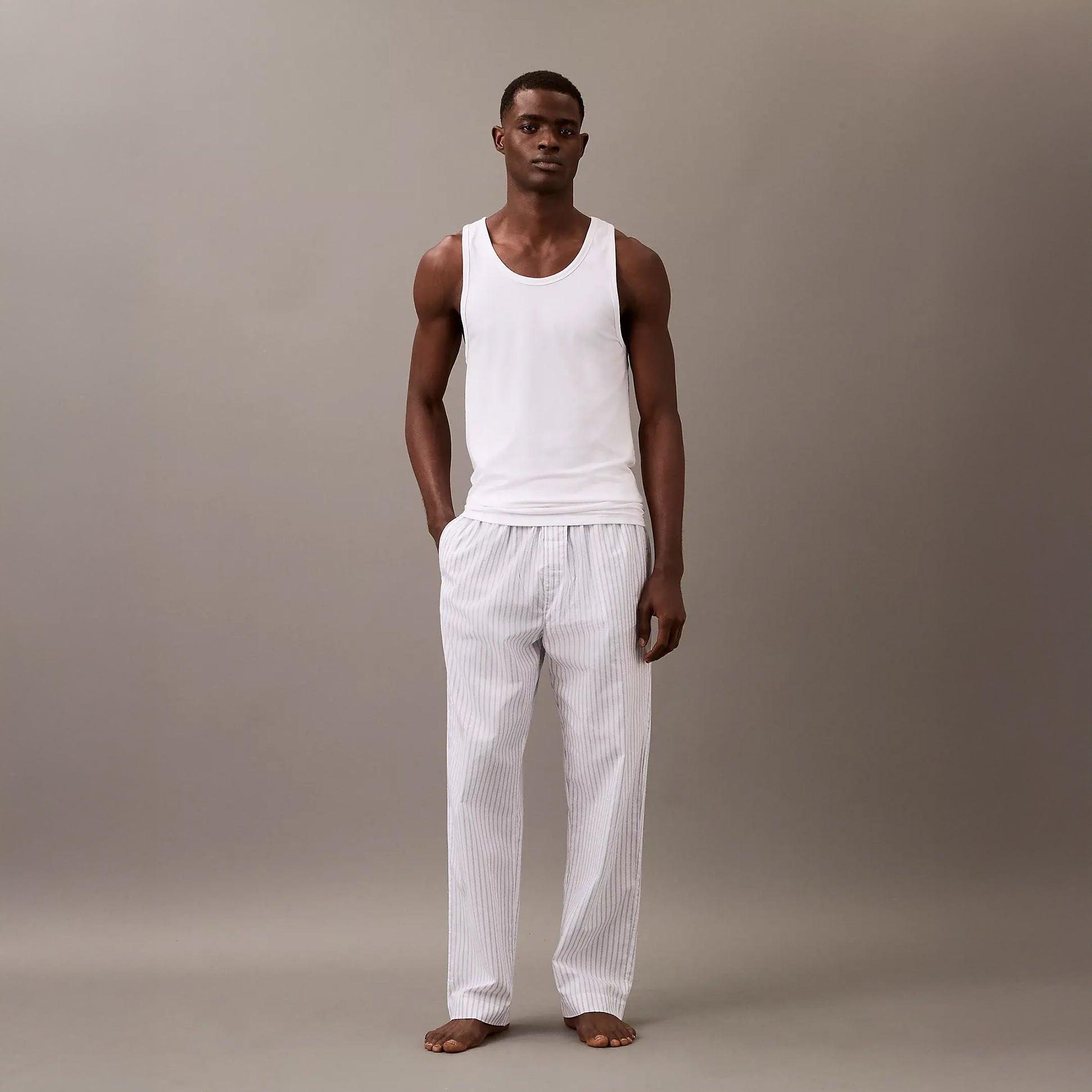 Calvin Klein 3 Pack Mens Lounge Tank Tops White front view on model wearing casual lounge pants.