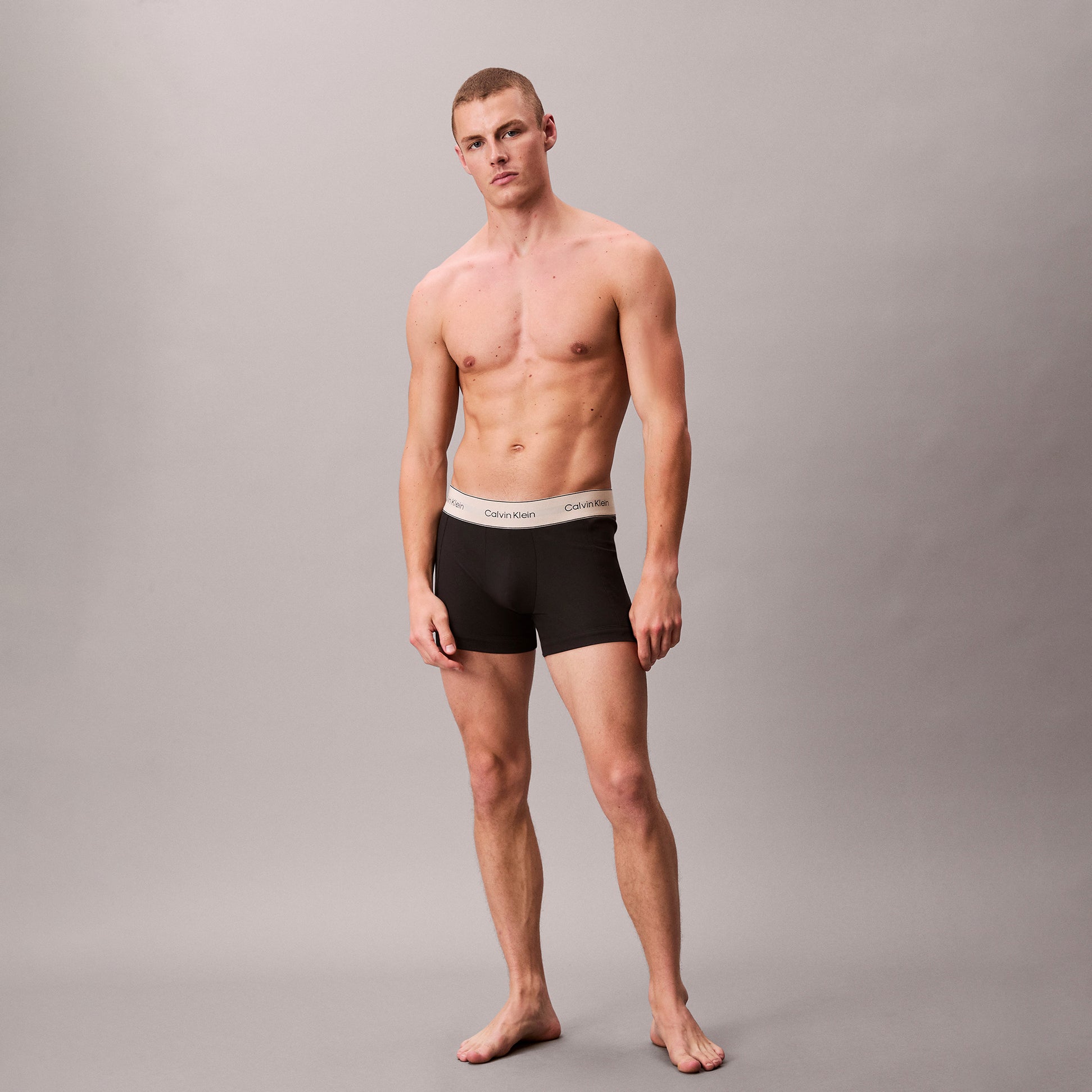 Calvin Klein TRUNK 3 Pack Mens Black side view, featuring a model wearing black trunk underwear with a logo waistband.