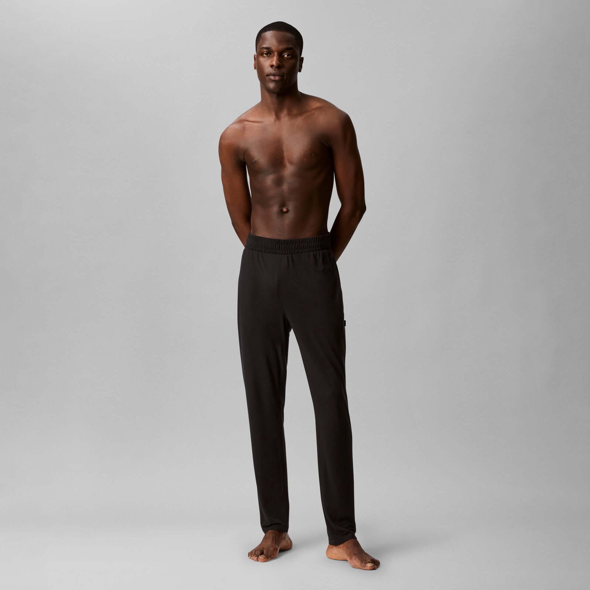 Calvin Klein ULTRA SOFT MODAL Mens Lounge Bottoms Black front view on model, featuring cuffed tapered leg and CK tonal elastic waistband.