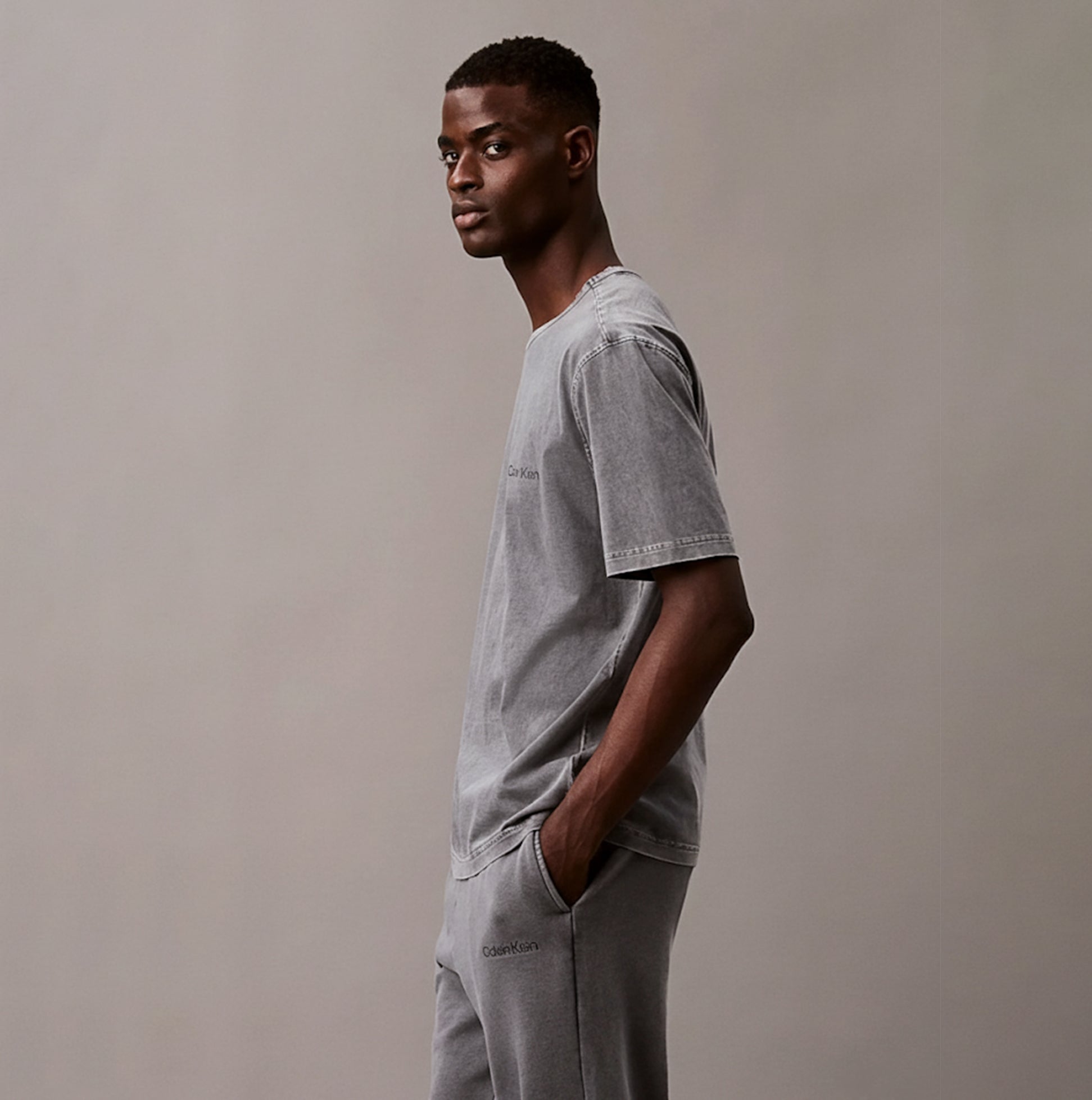 Calvin Klein 100% COTTON Mens Lounge T-Shirt Forged Iron side view model wearing gray T-shirt with crew neckline.