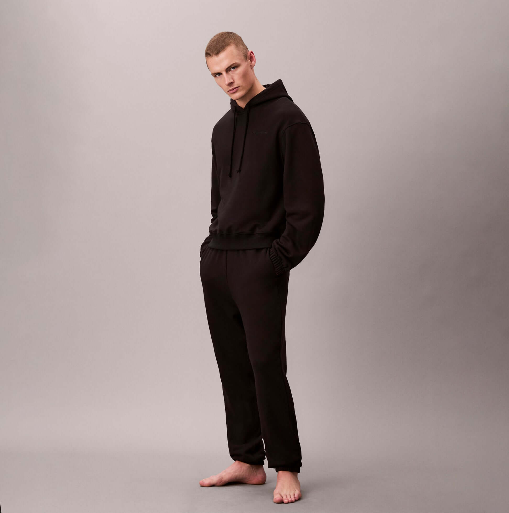 Calvin Klein L/S HOODIE Mens Hoodie Black front view, model wearing relaxed fit black hoodie and matching pants.