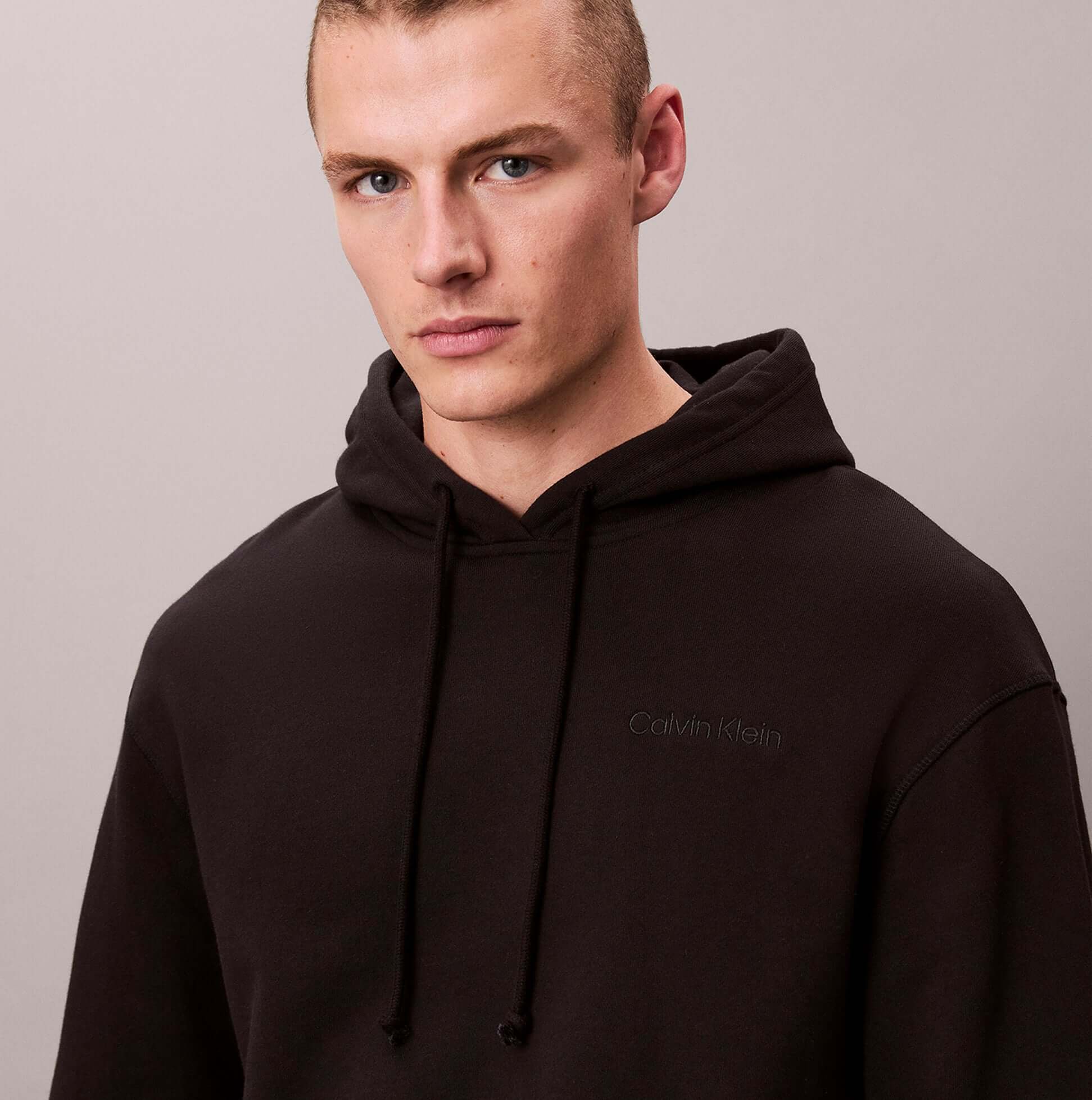 Calvin Klein L/S HOODIE Mens Hoodie Black front view, model wearing black relaxed hoodie, 85% cotton 15% polyester.