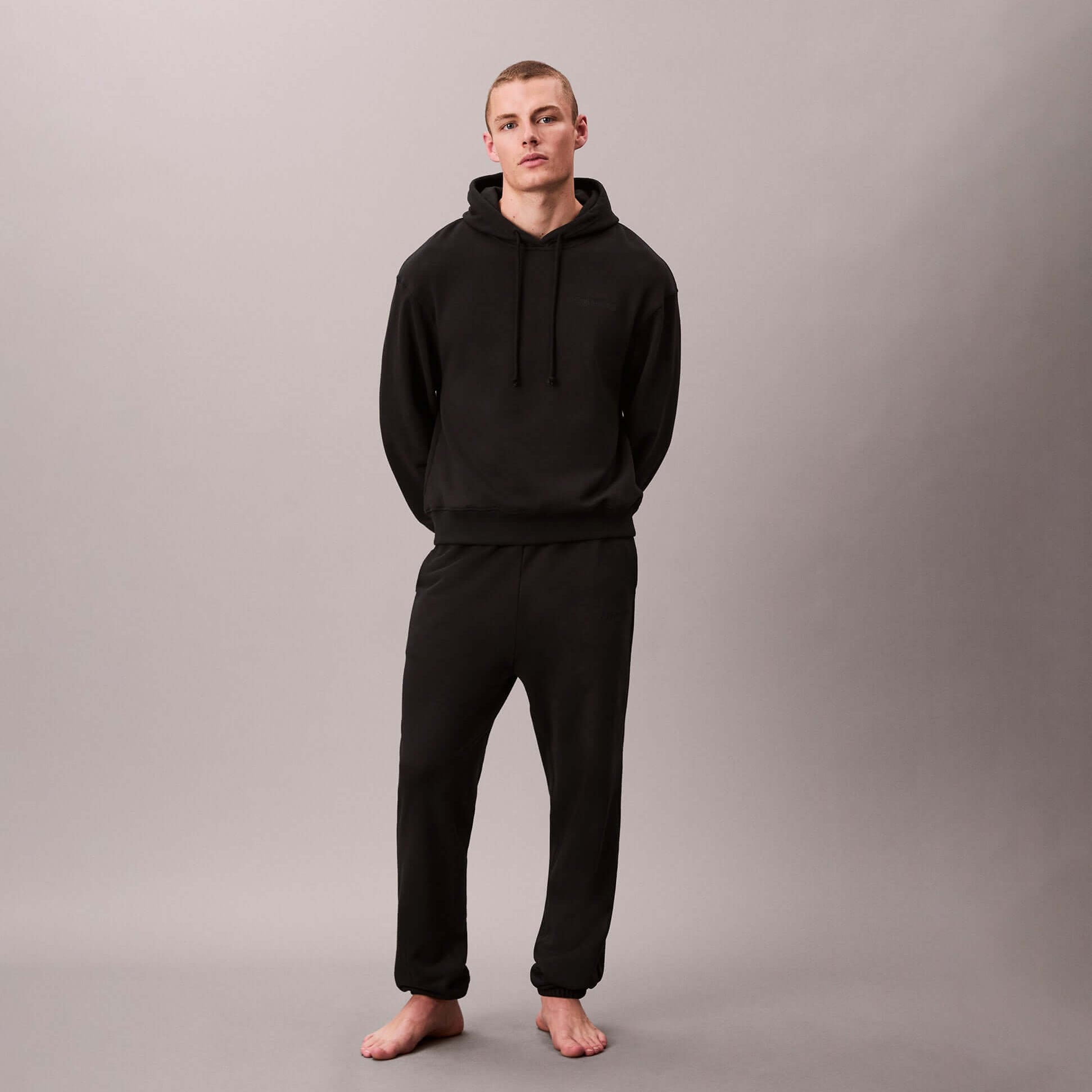 Calvin Klein JOGGER Mens Black front view model wearing outfit in black, featuring hoodie and jogger pants.