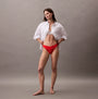 Calvin Klein THONG Womens Icon Logo Lace Molten Red side view model wearing a white shirt and red lace thong.