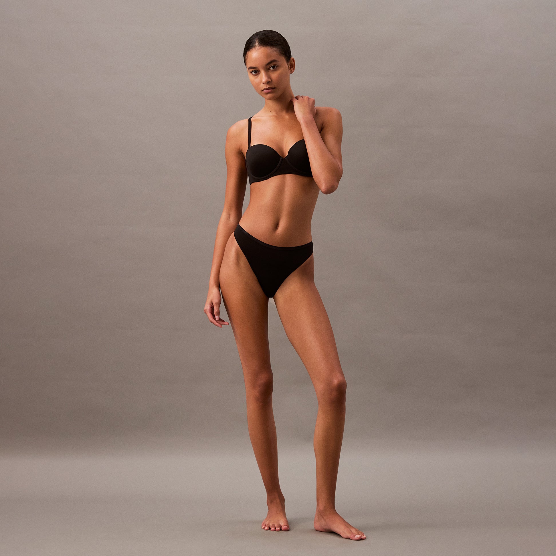 Calvin Klein THONG Womens Perfect Fit Black side view model wearing black thong underwear against a neutral background