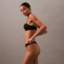 Calvin Klein THONG Womens Perfect Fit Black side view on model, showcasing the sleek design and fit.