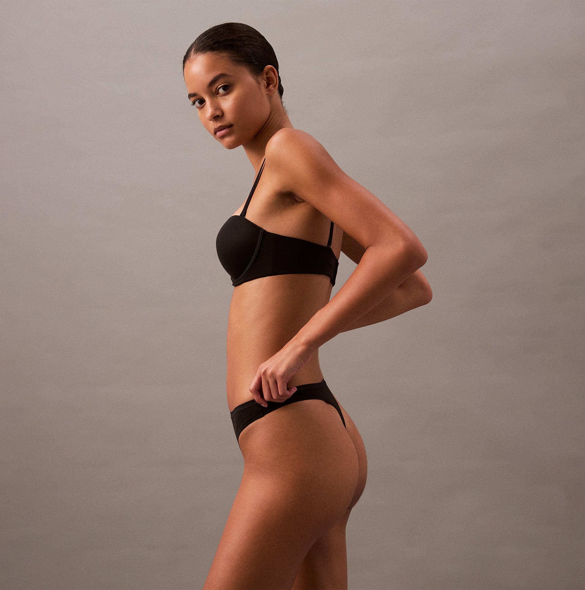 Calvin Klein THONG Womens Perfect Fit Black side view on model, showcasing the sleek design and fit.