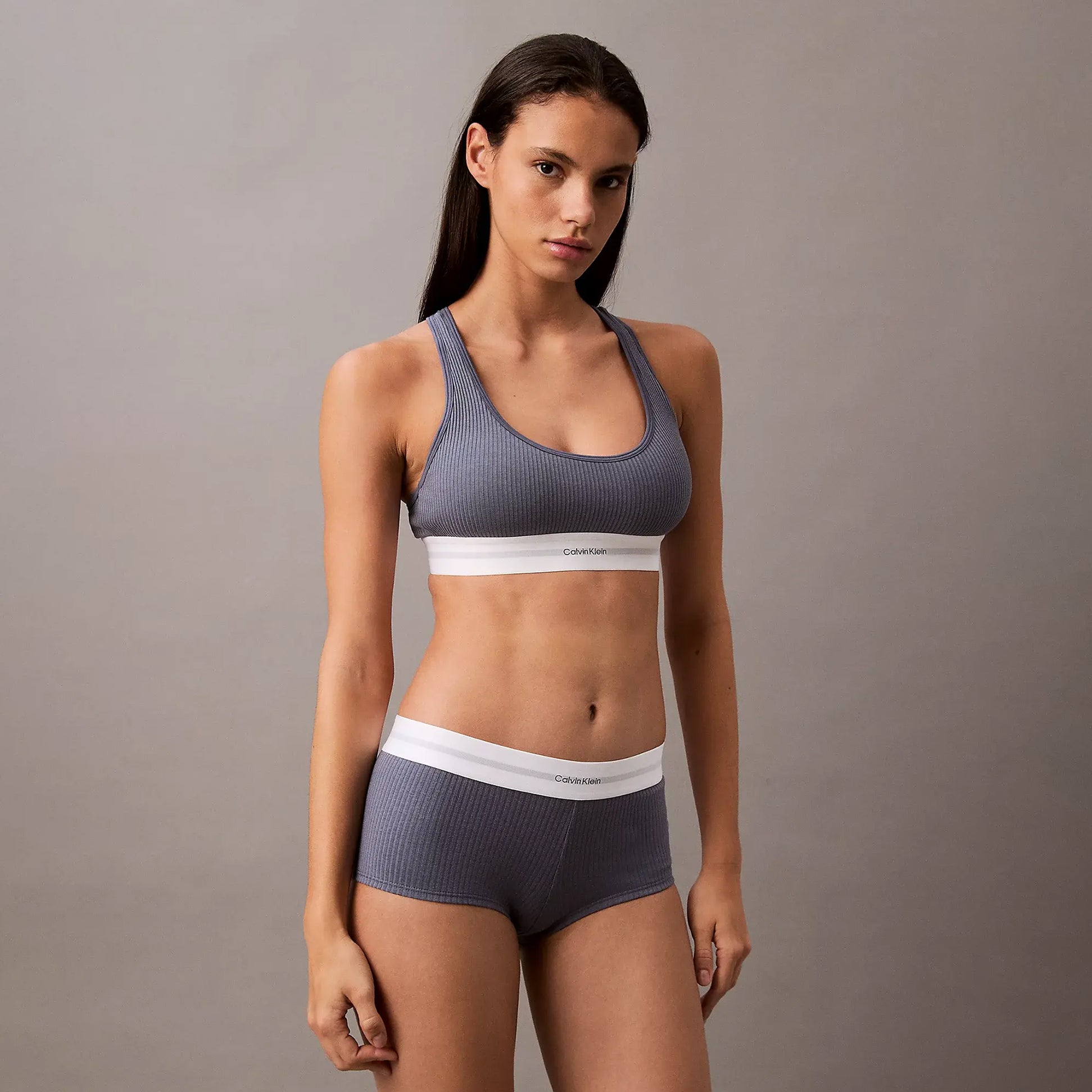 Calvin Klein Womens Hipster Panty BOYSHORTS Grey side view model wearing matching bra in a grey setting.