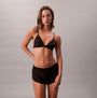 Calvin Klein UNLINED TRIANGLE Womens Black, front view of a model wearing a triangle bra with black shorts.