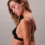 Calvin Klein UNLINED TRIANGLE Womens Black side view of a model wearing a black triangle bra, showcasing its elegant silhouette.