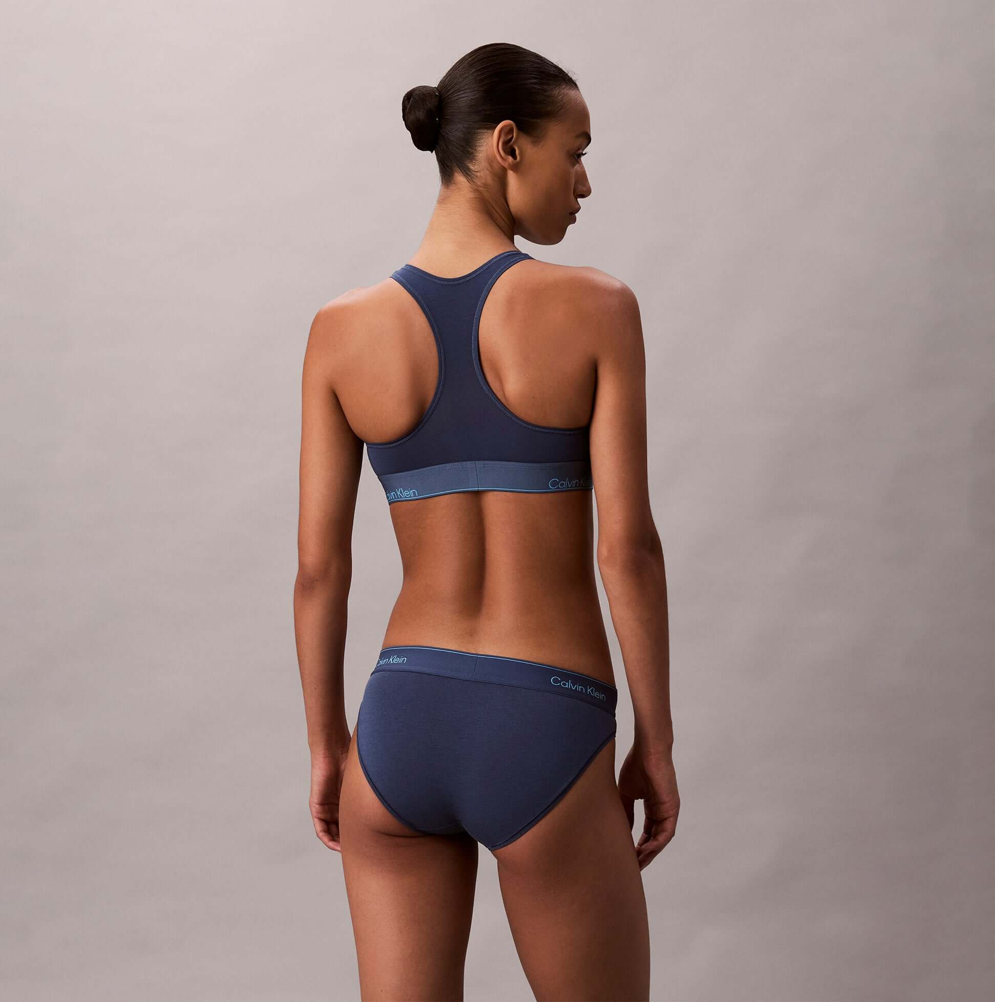 Calvin Klein Icon Cotton Modal Womens Unlined Bralette Denim back view on model, showcasing soft fabric and sporty design.
