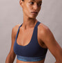 Calvin Klein Icon Cotton Modal Womens Unlined Bralette Denim side view on model, showcasing the fabric and fit.