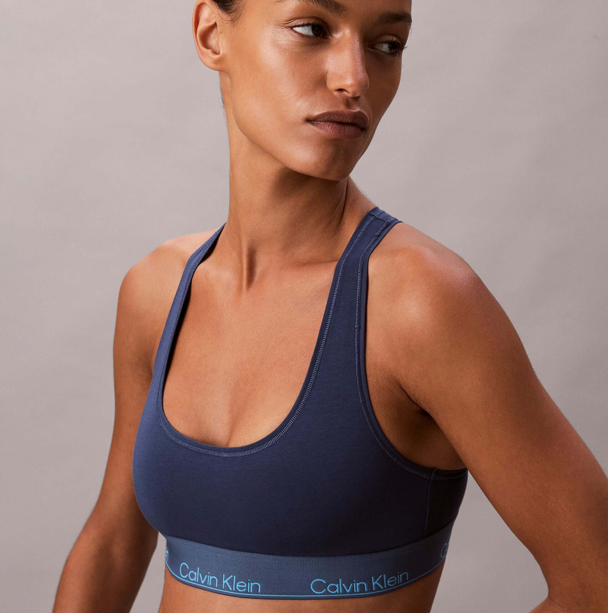 Calvin Klein Icon Cotton Modal Womens Unlined Bralette Denim side view on model, showcasing the fabric and fit.