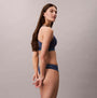 Calvin Klein Icon Cotton Modal Womens Thong Denim side view on model with navy bralette.