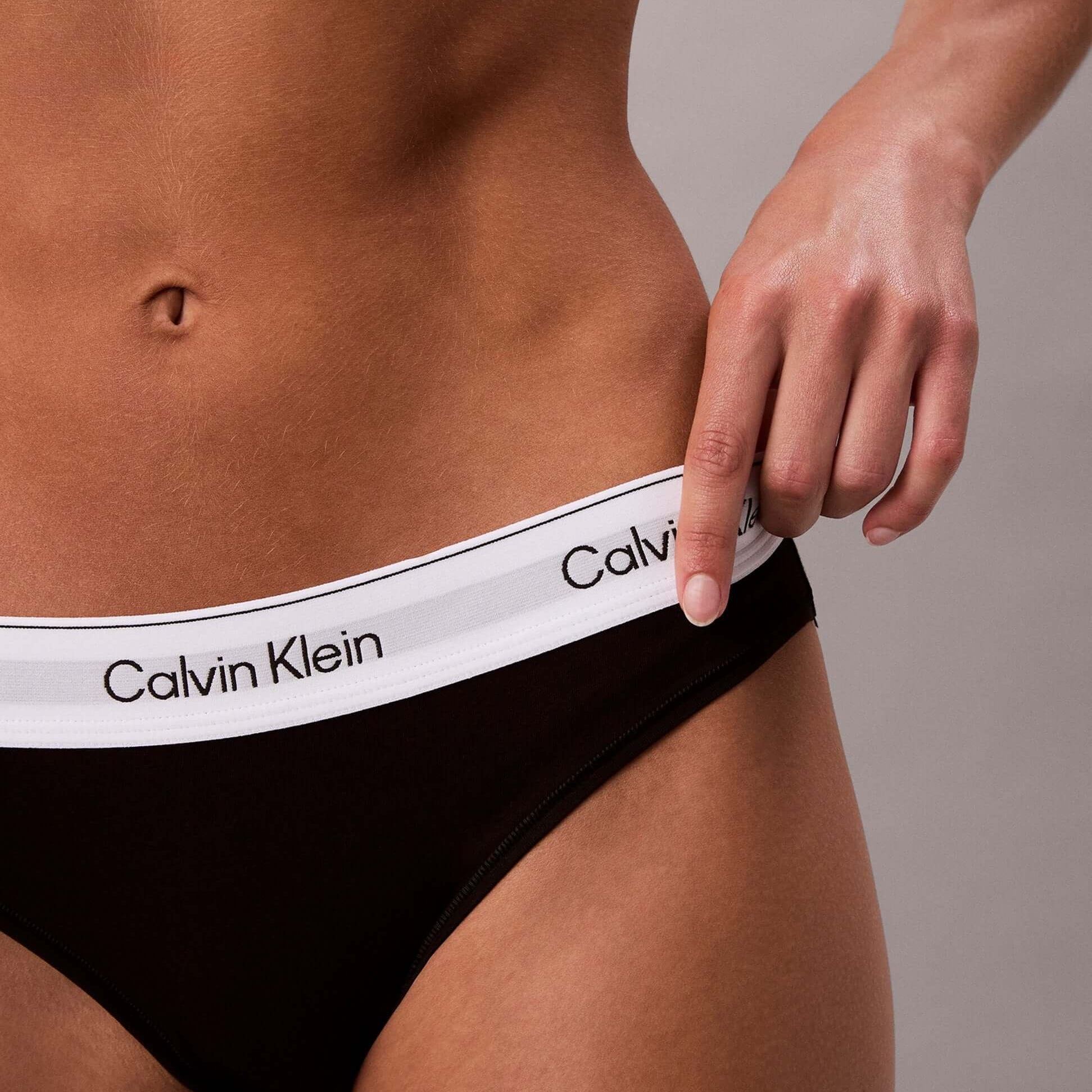 Calvin Klein Icon Cotton Modal Womens Bikini Briefs Black side view with model adjusting waistband