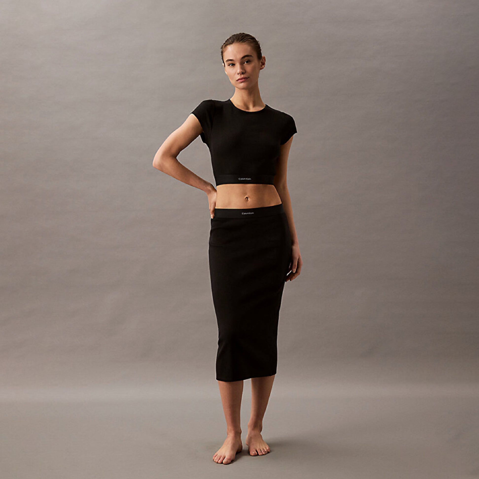 Calvin Klein COTTON STRETCH RIB Womens Crop Top Black front view on model with matching skirt and bare feet.