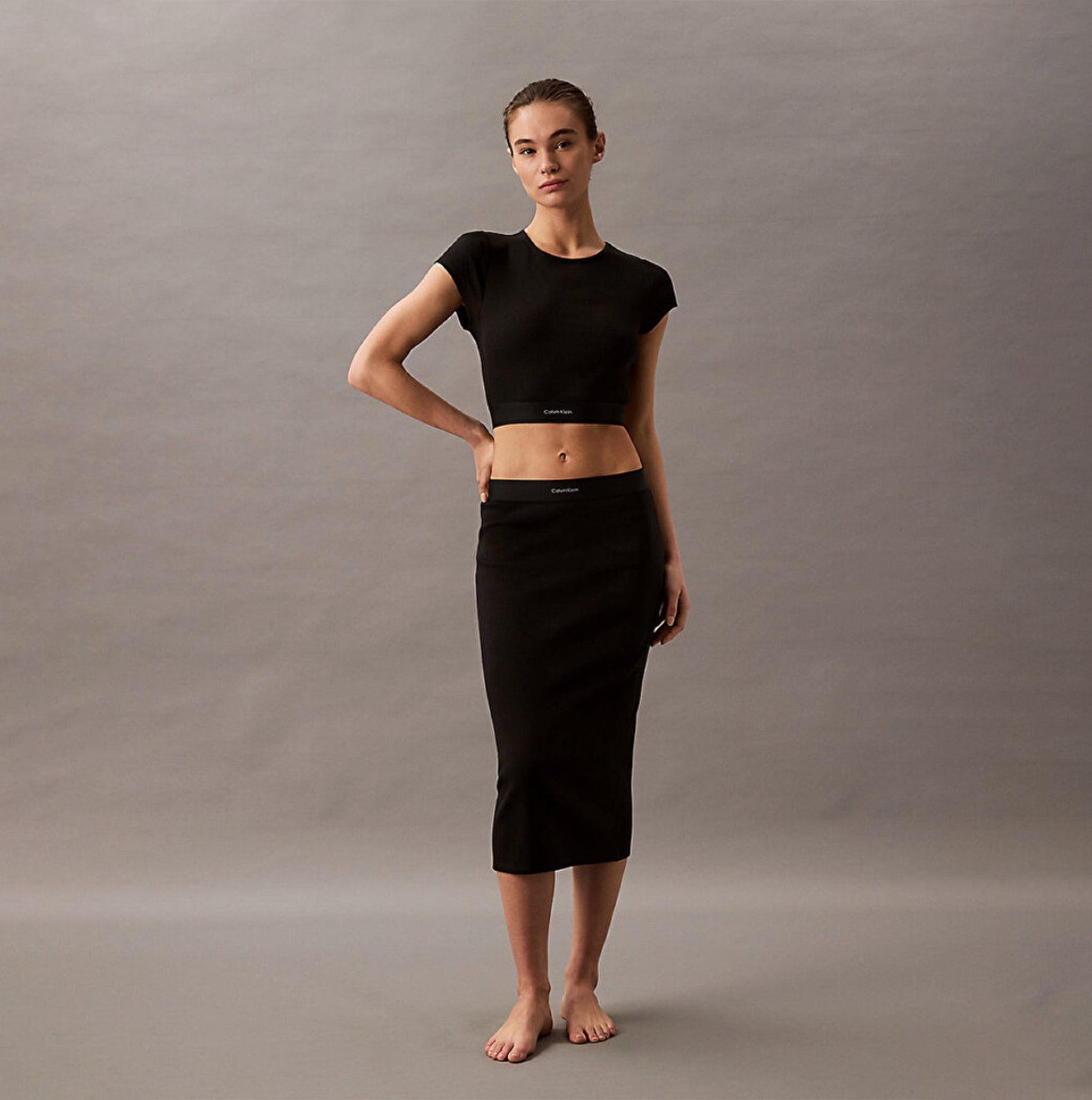 Calvin Klein COTTON STRETCH RIB Womens Crop Top Black front view on model with matching skirt and bare feet.