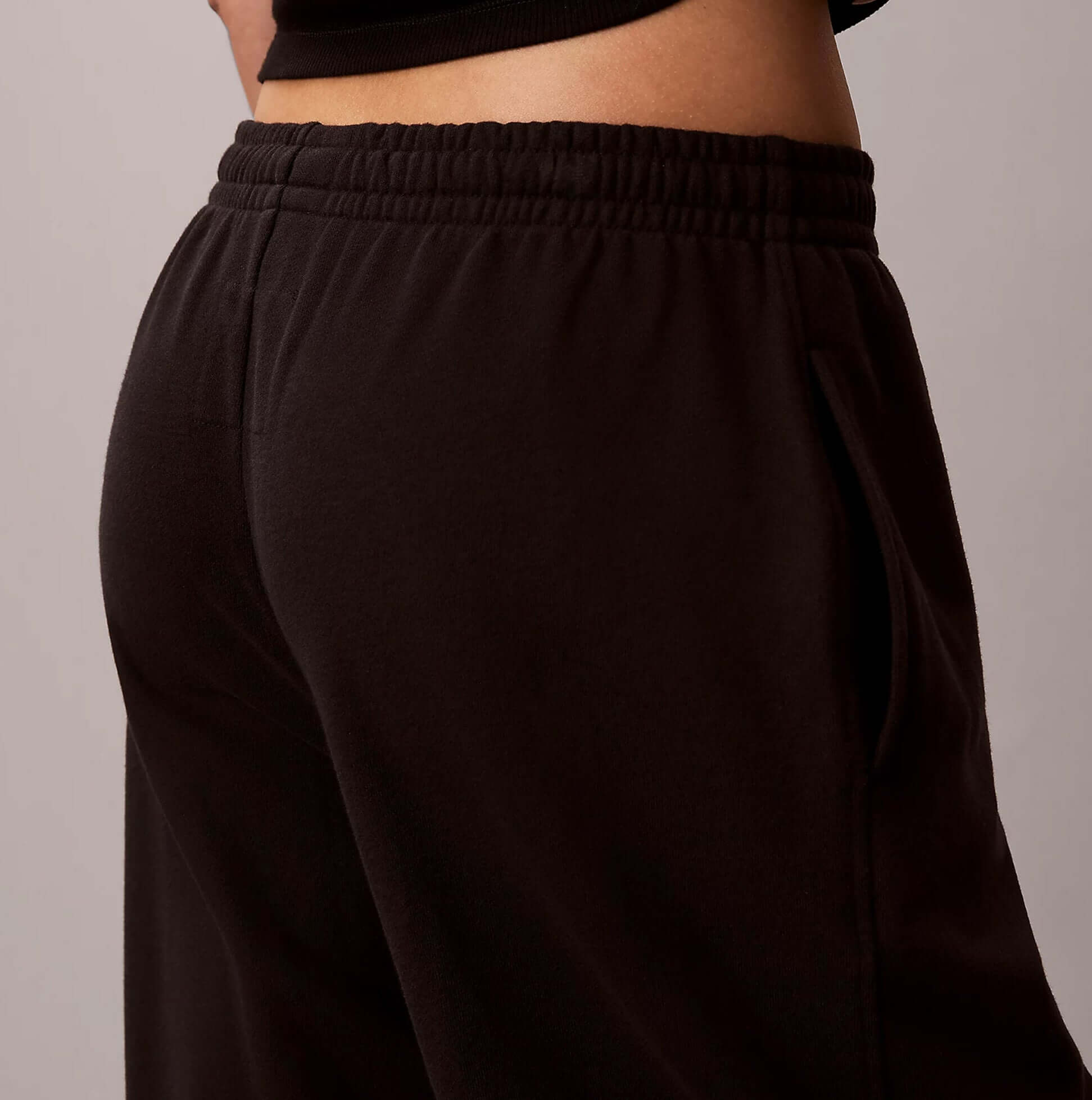 Calvin Klein JOGGER Womens Black side view of joggers showcasing elastic waistband and pocket detail.