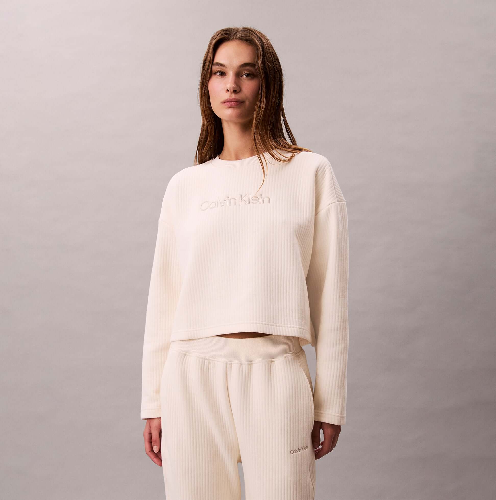 Calvin Klein LS QUILTED SWTSHIRT Womens Sweatshirts Ivory front view on model, featuring ribbed texture and logo.
