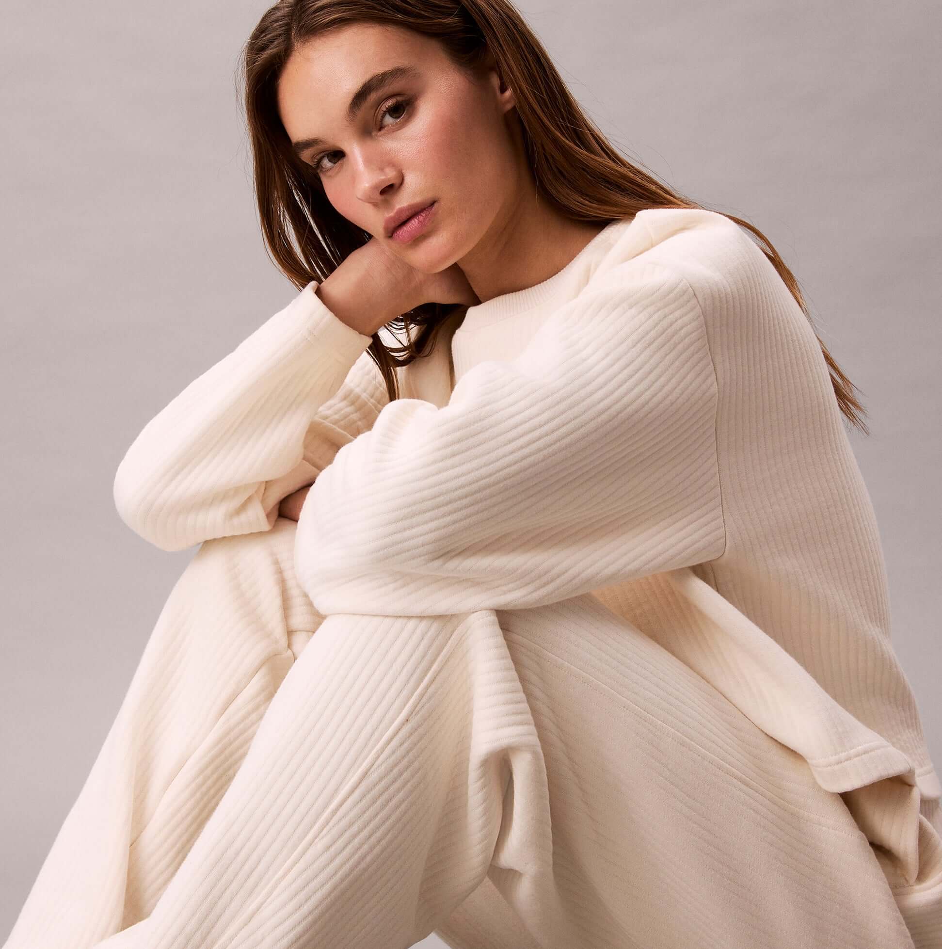 Calvin Klein QUILTED JOGGER Womens Ivory front view model sitting, showcasing soft material and relaxed fit.