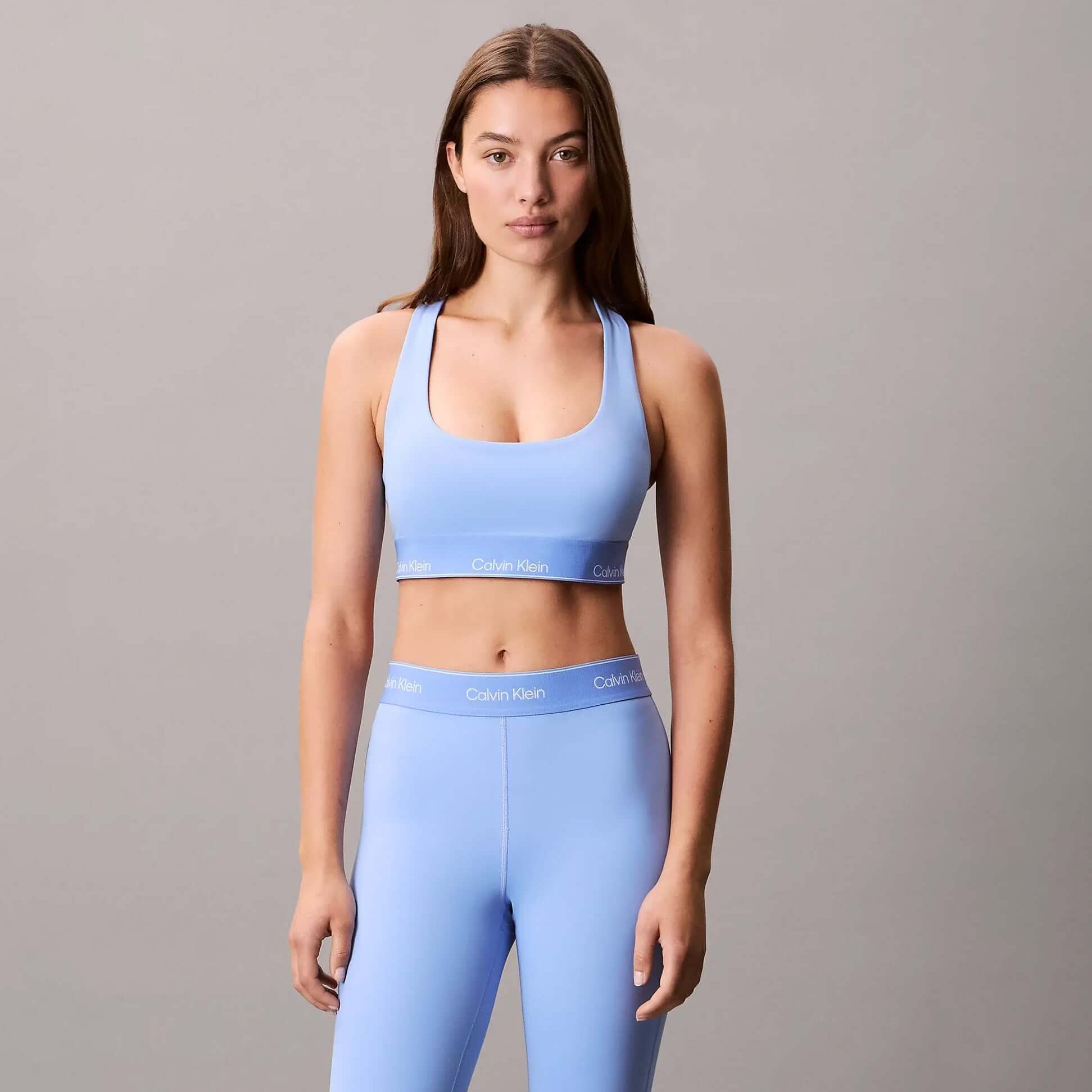 Calvin Klein Womens Quick-Dry Medium Impact Sports Bra Blue front view worn with matching leggings, designed for comfort and style.