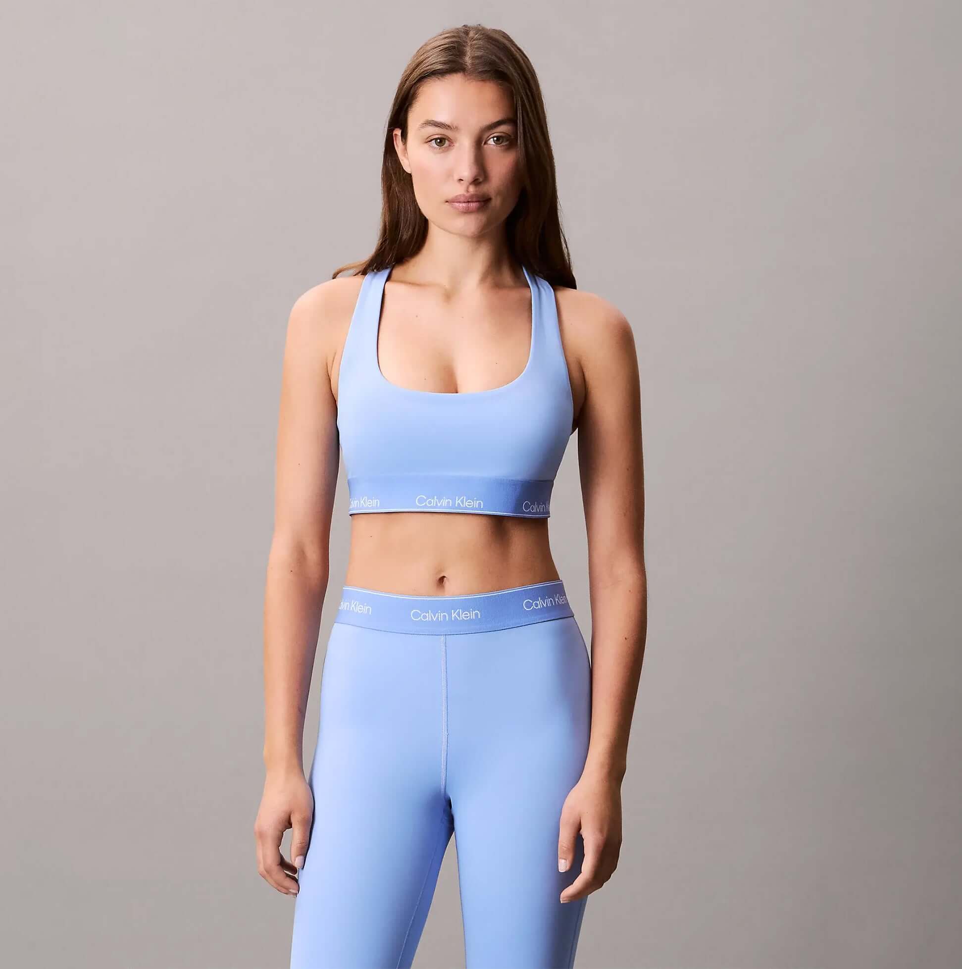 Calvin Klein Womens Quick-Dry Medium Impact Sports Bra Blue front view worn with matching leggings, designed for comfort and style.