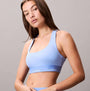 Calvin Klein Womens Quick-Dry Medium Impact Sports Bra Blue front view showcasing a model wearing a light blue sports bra.