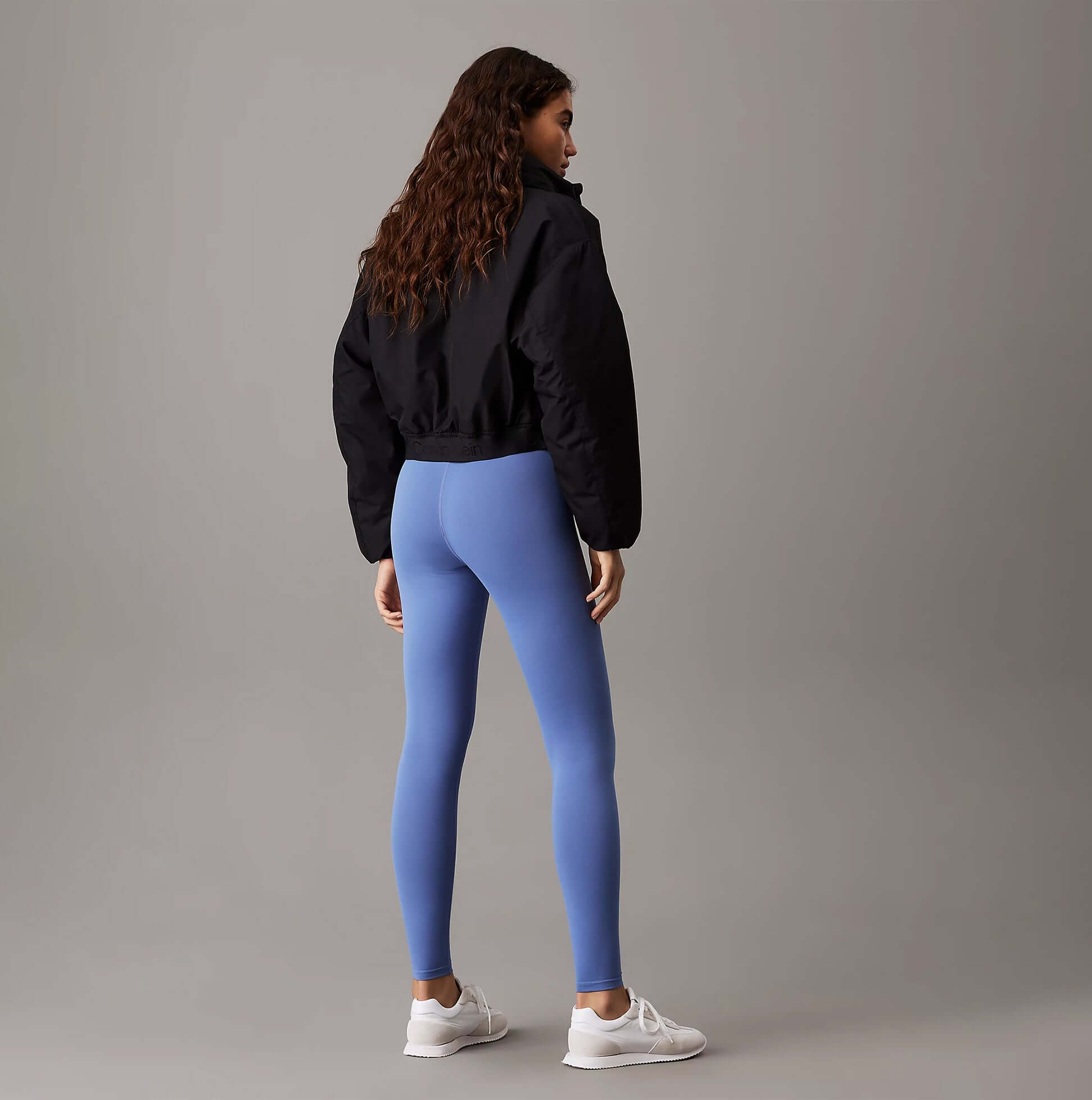Calvin Klein LEGGING FULL Ladies Full Length Leggings Glacier back view on model wearing black jacket and white sneakers.