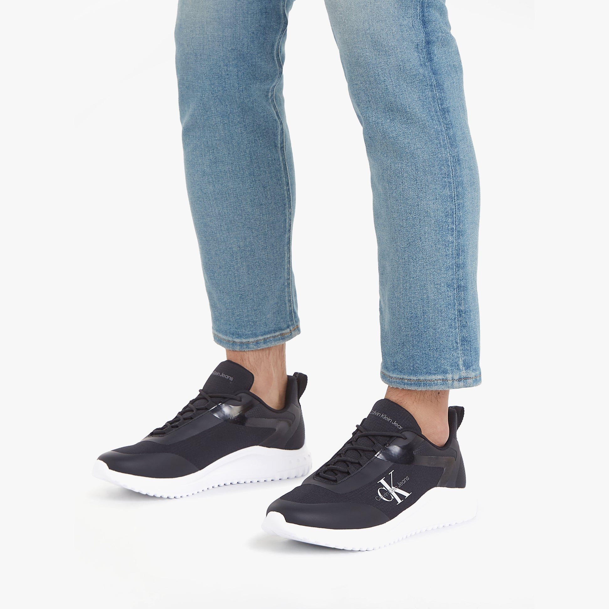 Calvin Klein EVA RUNNER LOW LACE Mens Trainers Black/Bright White side view worn with jeans