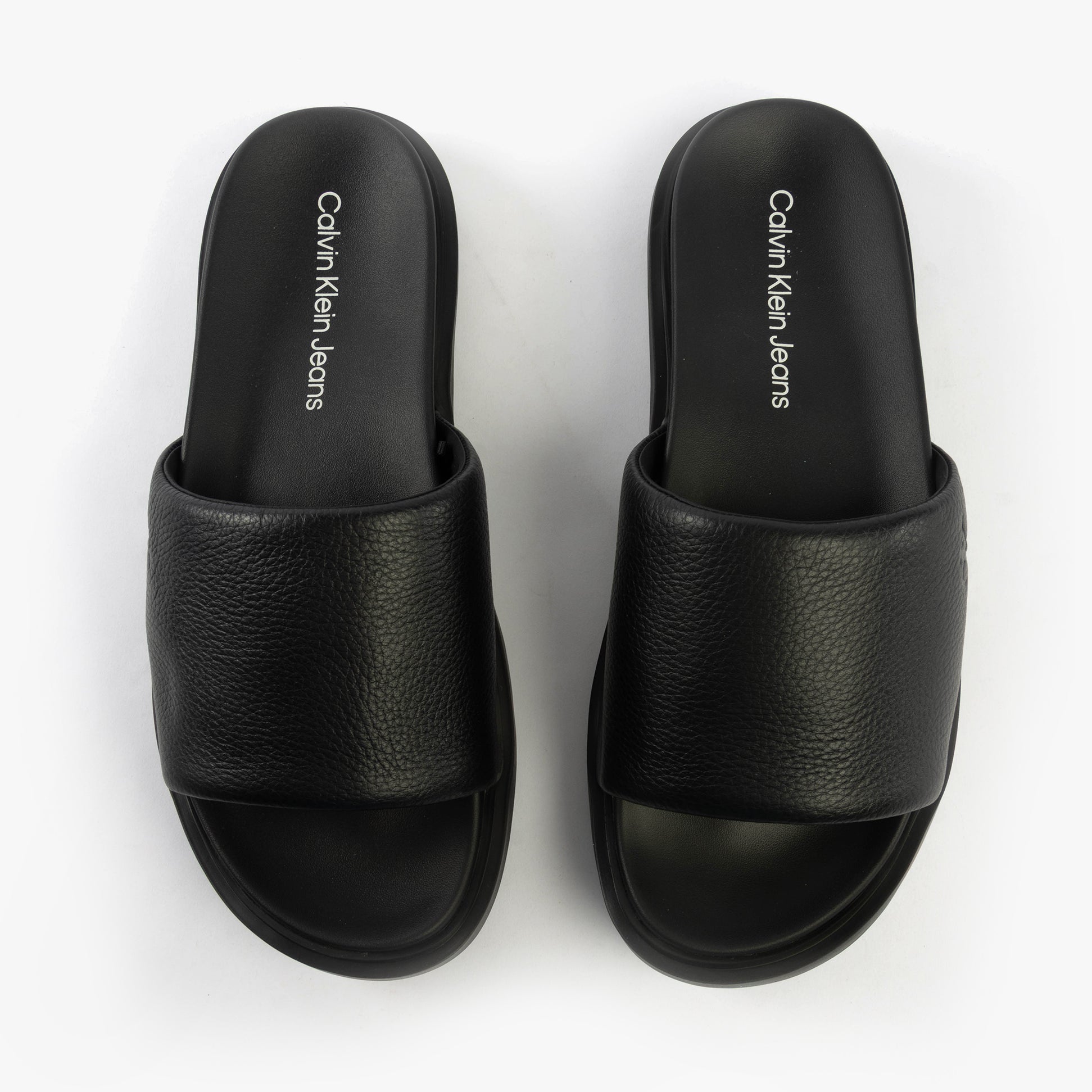Calvin Klein FLAT MOLDED SLIDE Mens Triple Black top view showcasing leather upper and slip-on design.