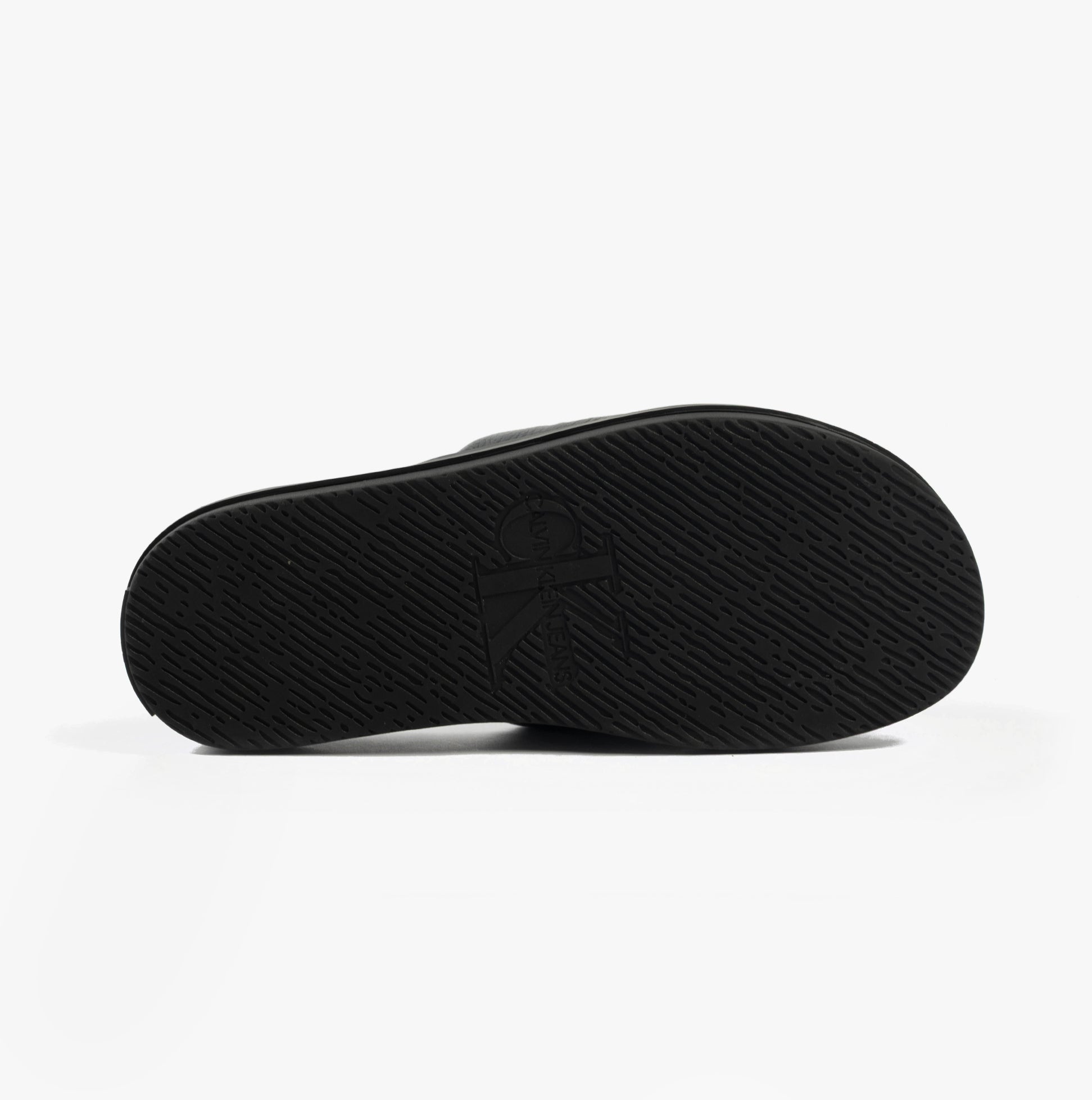 Calvin Klein FLAT MOLDED SLIDE Mens Triple Black bottom view showing the textured EVA sole with logo detail.