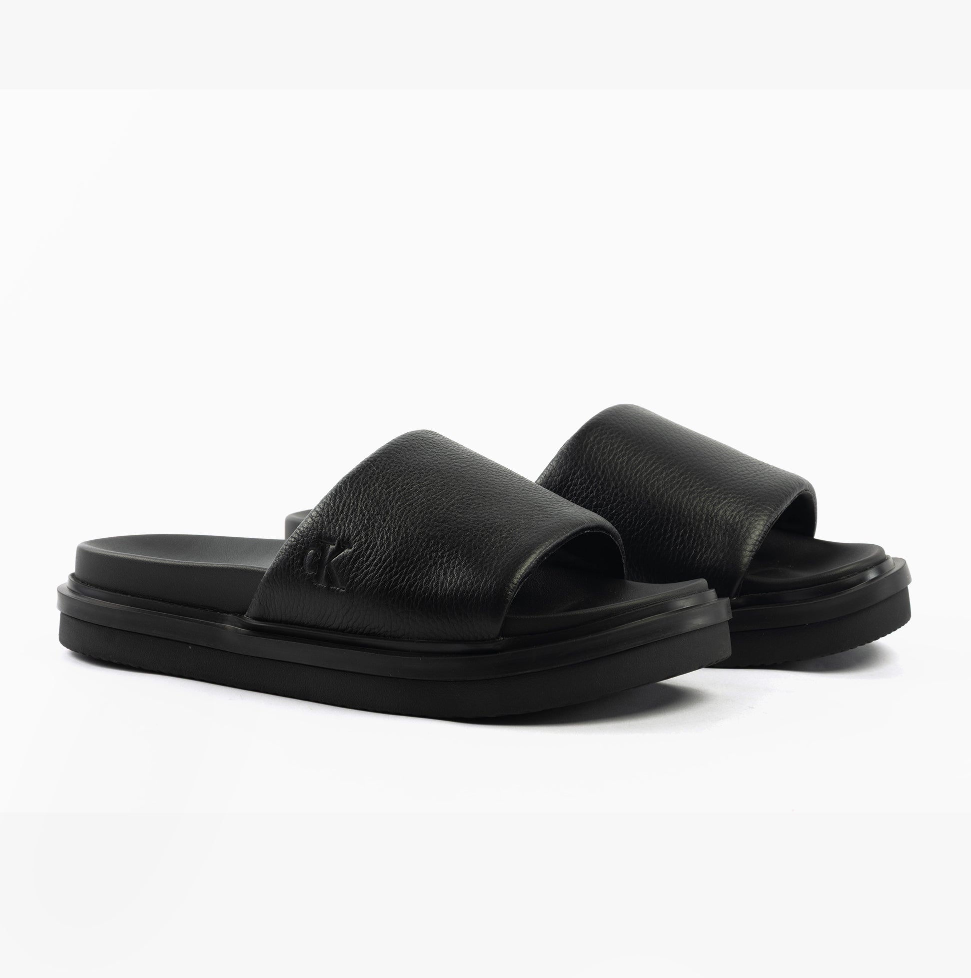 Calvin Klein FLAT MOLDED SLIDE Mens Triple Black side view showcasing leather upper and slip-on design.