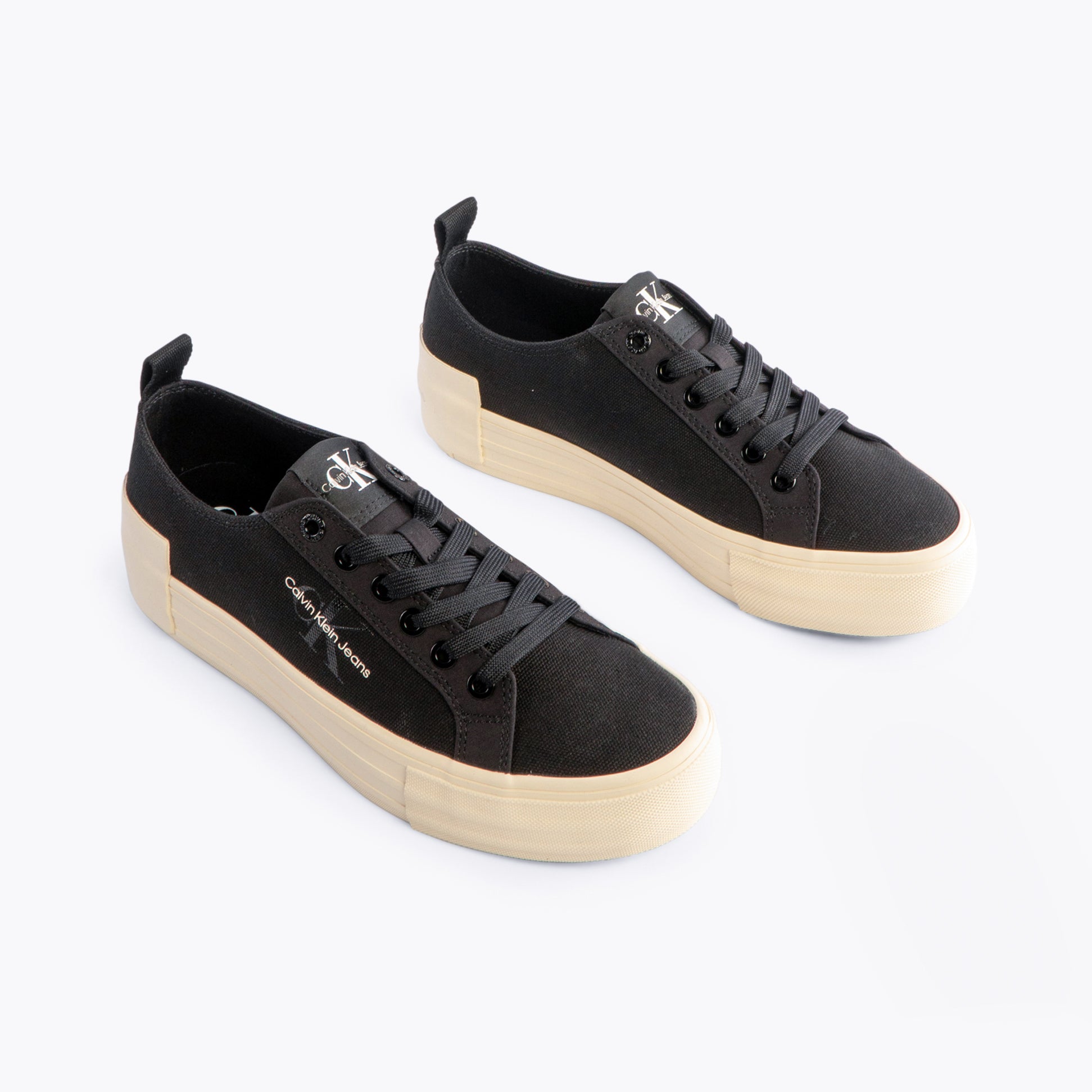 Calvin Klein BOLD VULCANISED Womens Trainers Black/Creamy White side view showcasing canvas upper and platform sole.