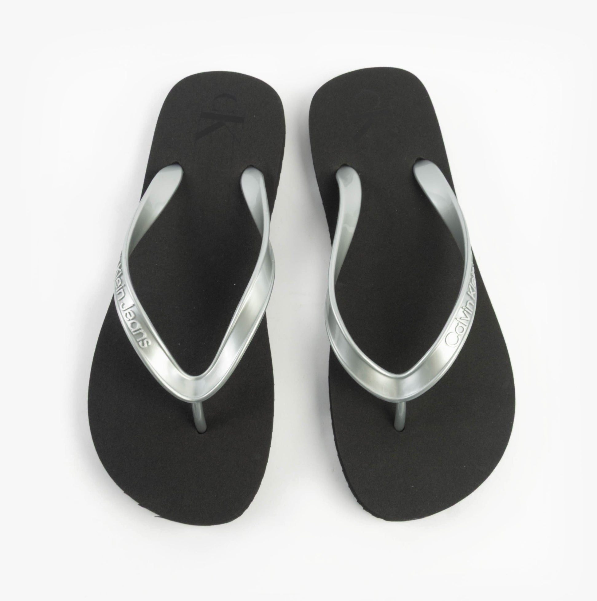 Calvin Klein BEACH SANDAL MONOLOG Womens Sandals Black/Silver top view showcasing the flat design and silver accents.