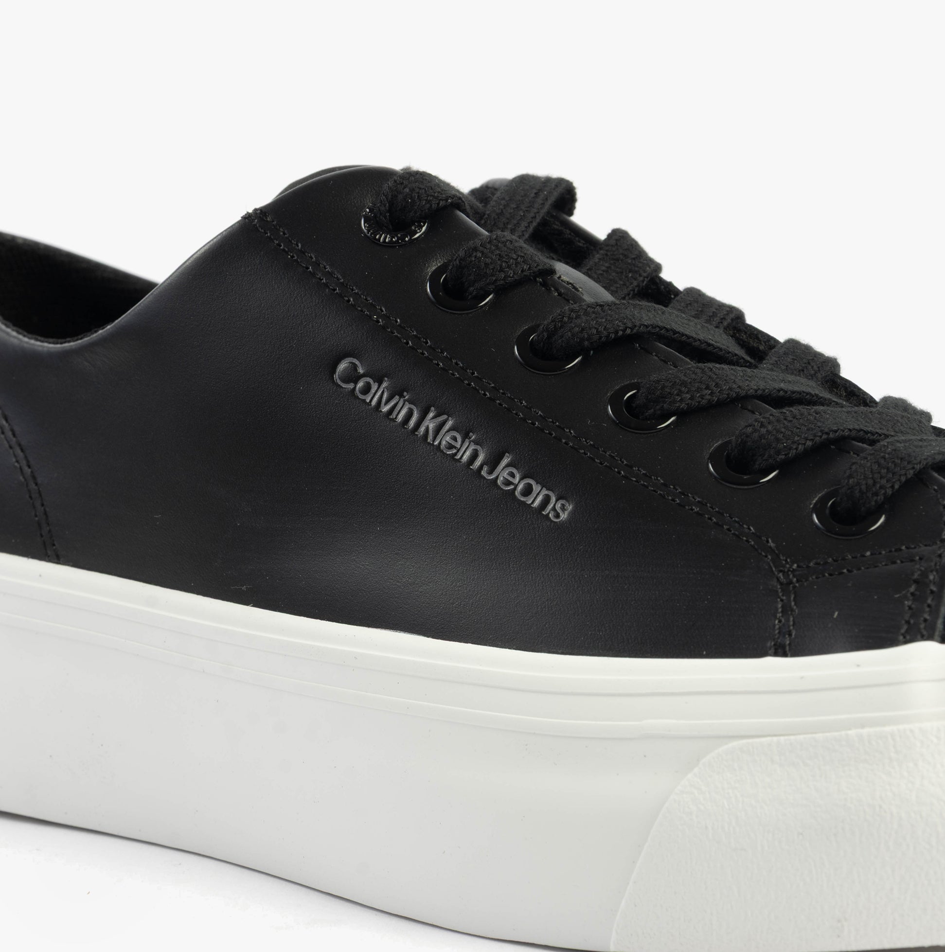 Calvin Klein VULC FLATFORM LOW Womens Trainers Black/Bright White detail view showing black leather upper and white platform sole.