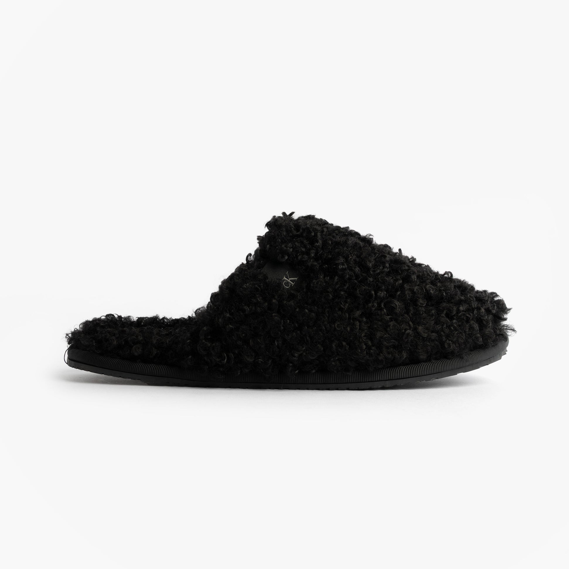 Calvin Klein CLOSE SLIPPER FUR Womens Slippers Black side view showing faux fur texture and slip-on design.