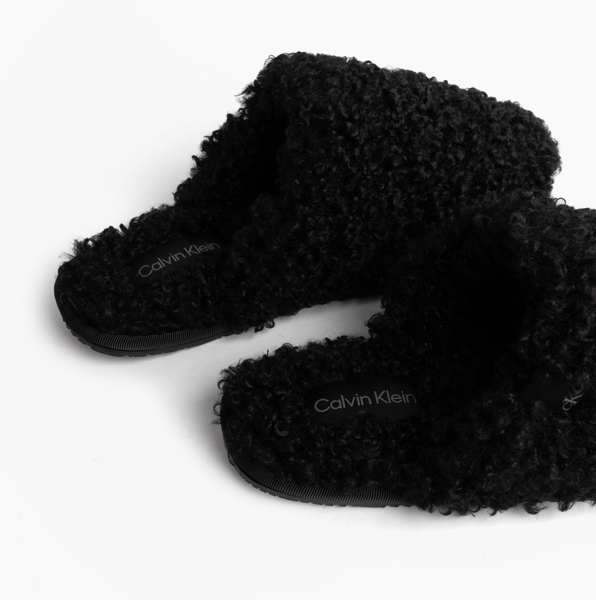 Calvin Klein CLOSE SLIPPER FUR Womens Slippers Black side view showcasing faux fur material and slip-on design.