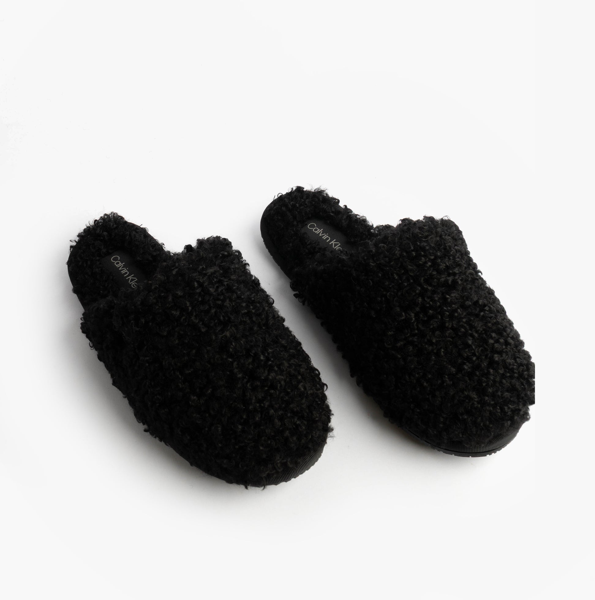 Calvin Klein CLOSE SLIPPER FUR Womens Slippers Black top view with cozy faux fur material and slip-on design.