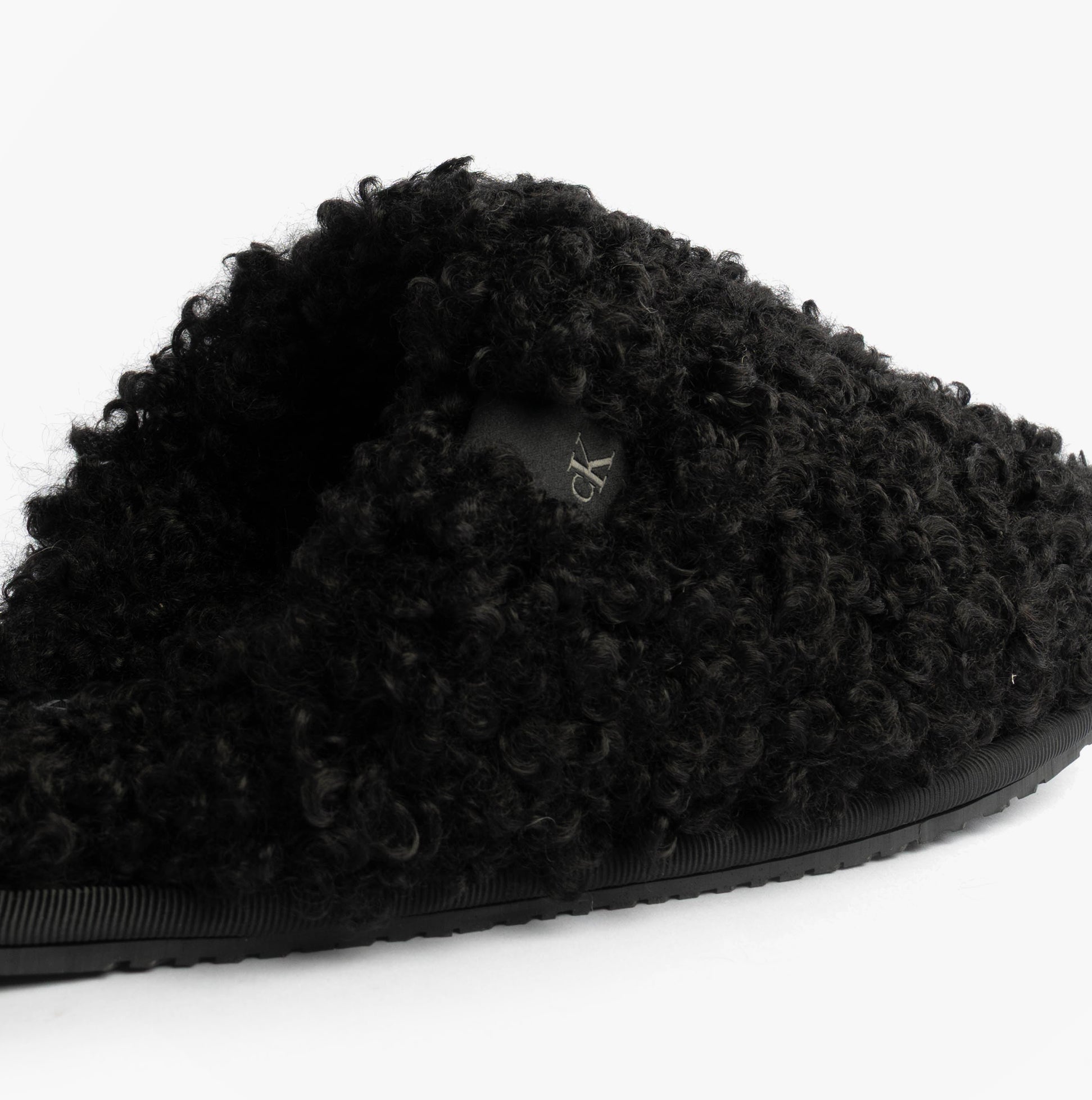 Calvin Klein CLOSE SLIPPER FUR Womens Slippers Black side view showcasing faux fur upper and slip-on design.
