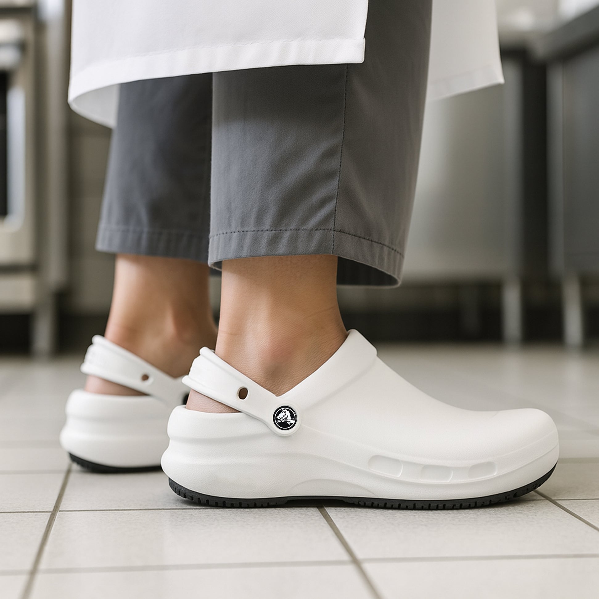 Crocs At Work BISTRO Unisex Slip-Resistant Work Clogs White side view on a person's feet in a kitchen.