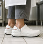 Crocs At Work BISTRO Unisex Slip-Resistant Work Clogs White side view on a person's feet in a kitchen.