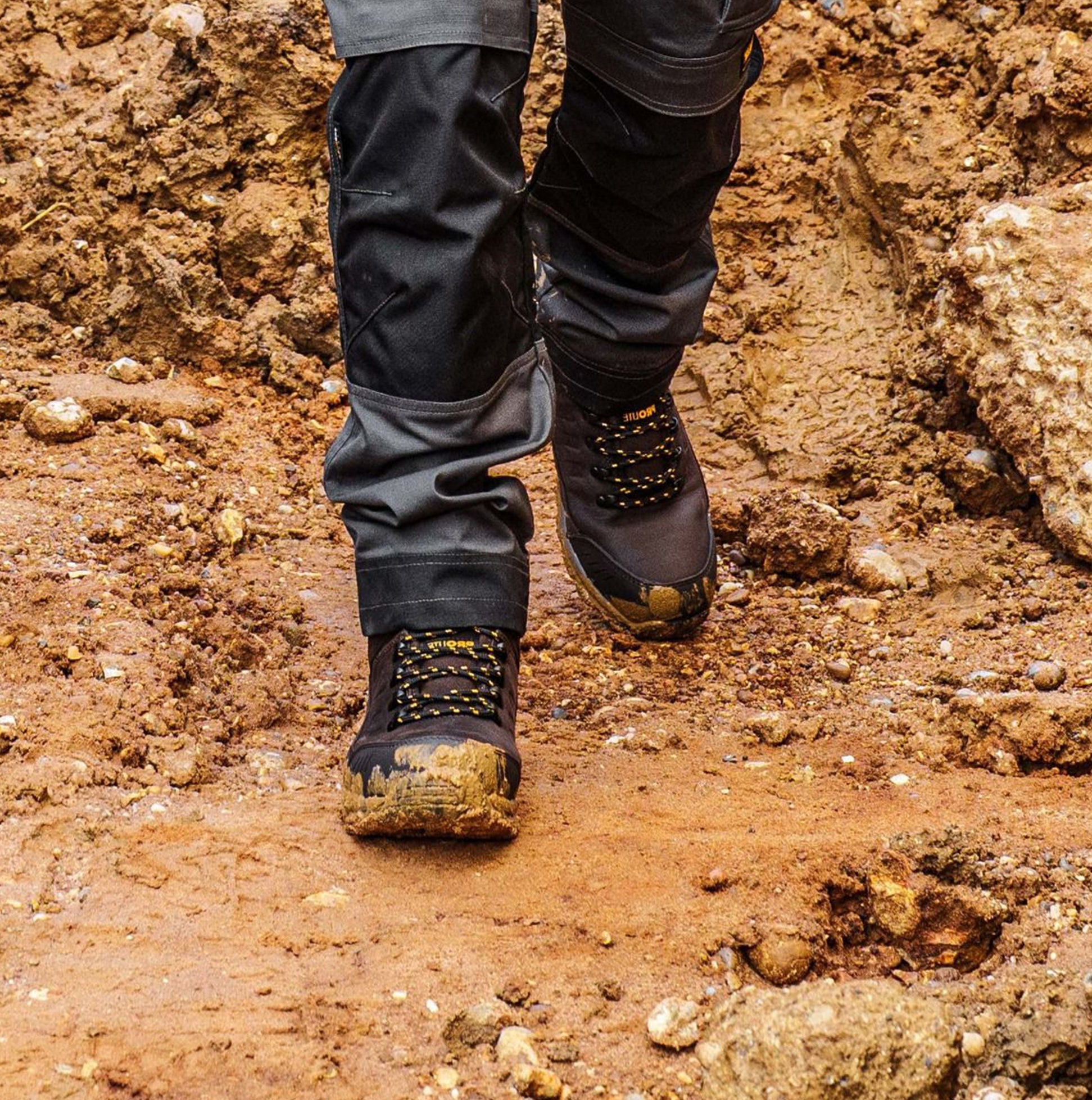 Dewalt KIRKSVILLE Mens Boots Brown side view on muddy terrain, showcasing rubber sole and lace-up design.