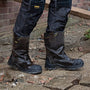 Dewalt MILLINGTON Unisex Boots Brown side view on wet ground, showcasing safety features and pull-on design.