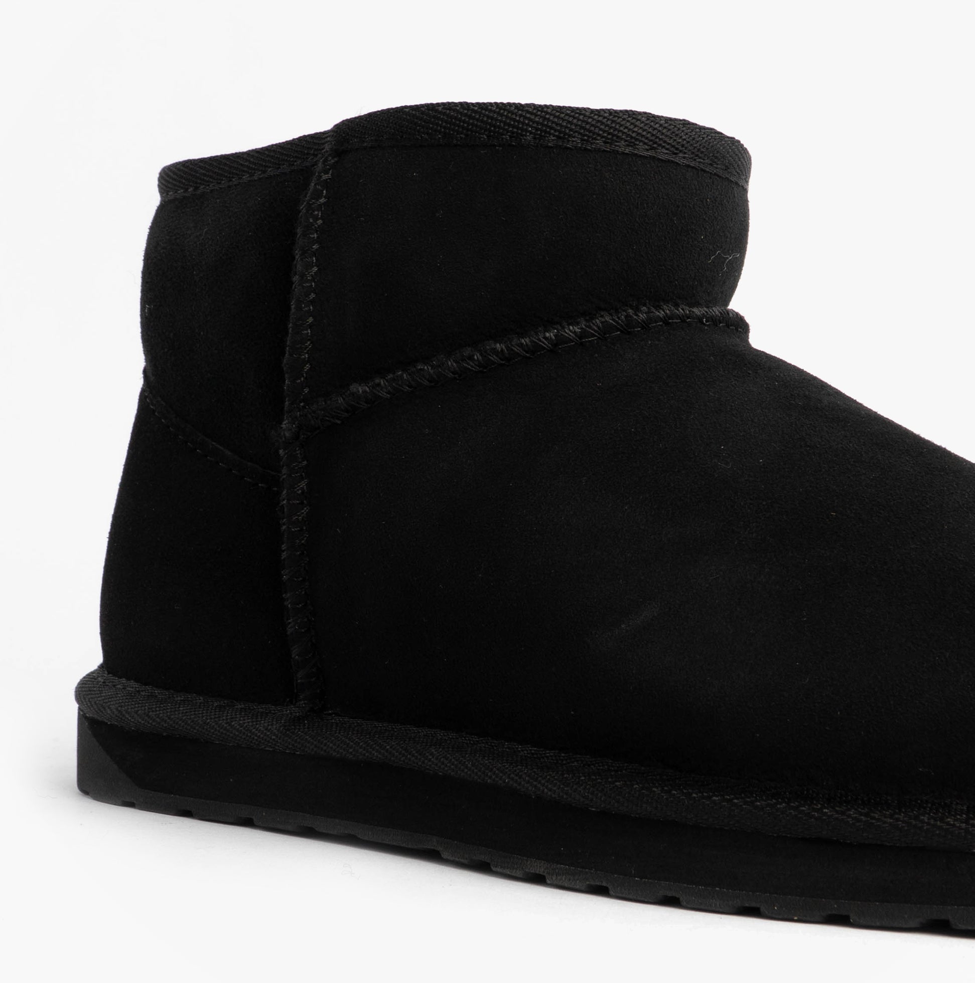 EMU Australia STINGER MICRO Womens Sheepskin Boot Black side view showcasing soft black sheepskin material and rubber sole.