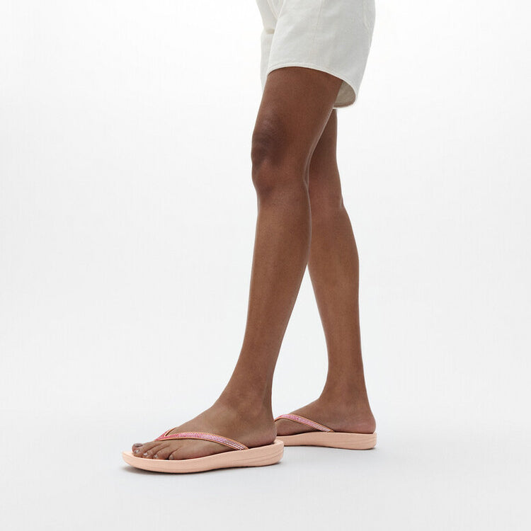 FitFlop IQUSHION Womens Flip Flops Beige side view worn by model standing, showcasing comfort and style.