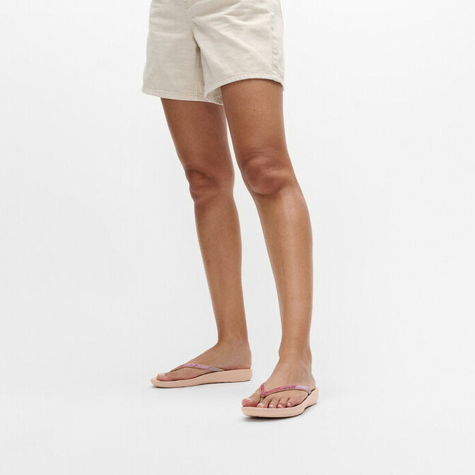 FitFlop IQUSHION Womens Flip Flops Beige side view on a woman, showcasing comfort and lightweight design.