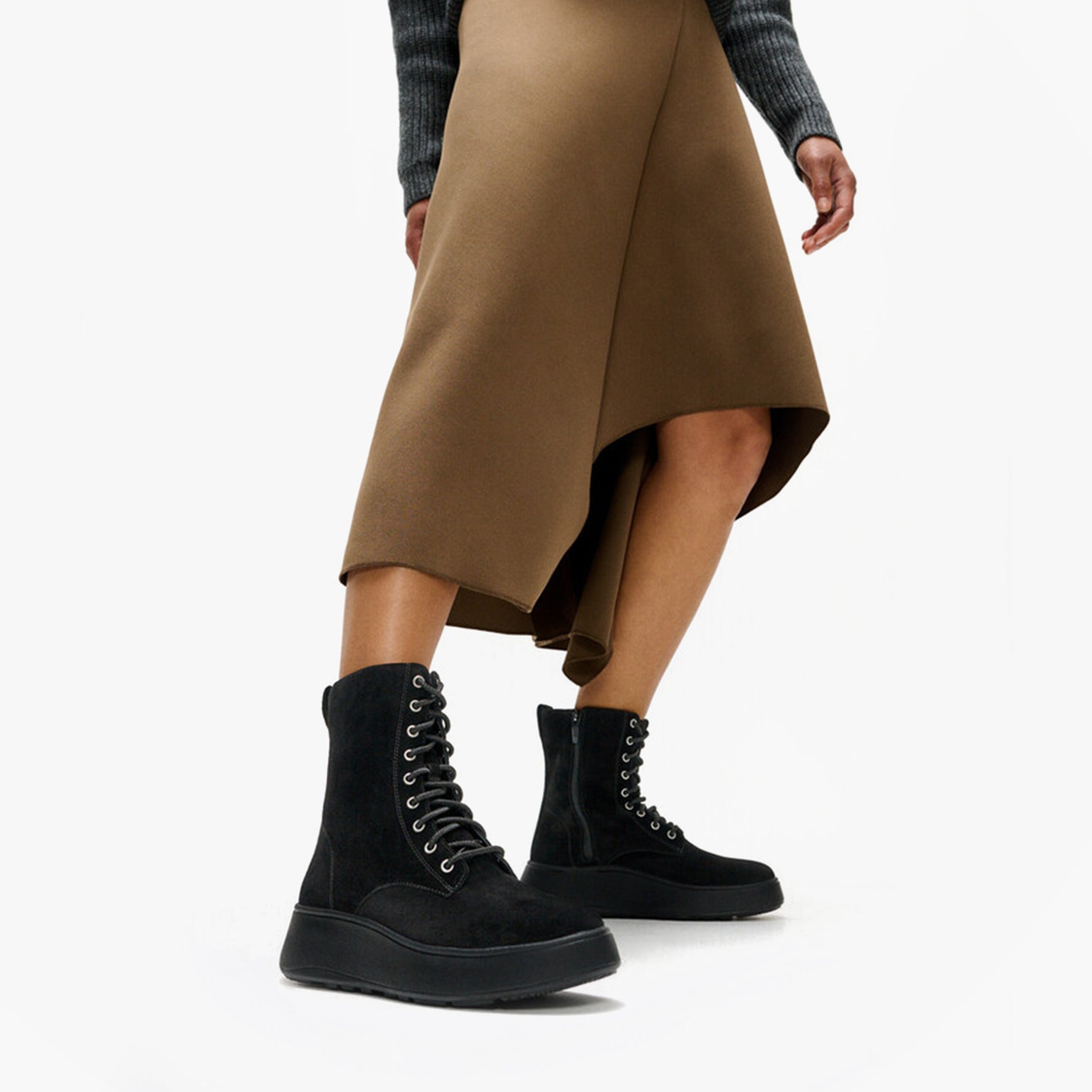 FitFlop F-MODE SUEDE LACE-UP FLATFORM Ladies Ankle Boots All Black side view on model wearing a brown skirt.