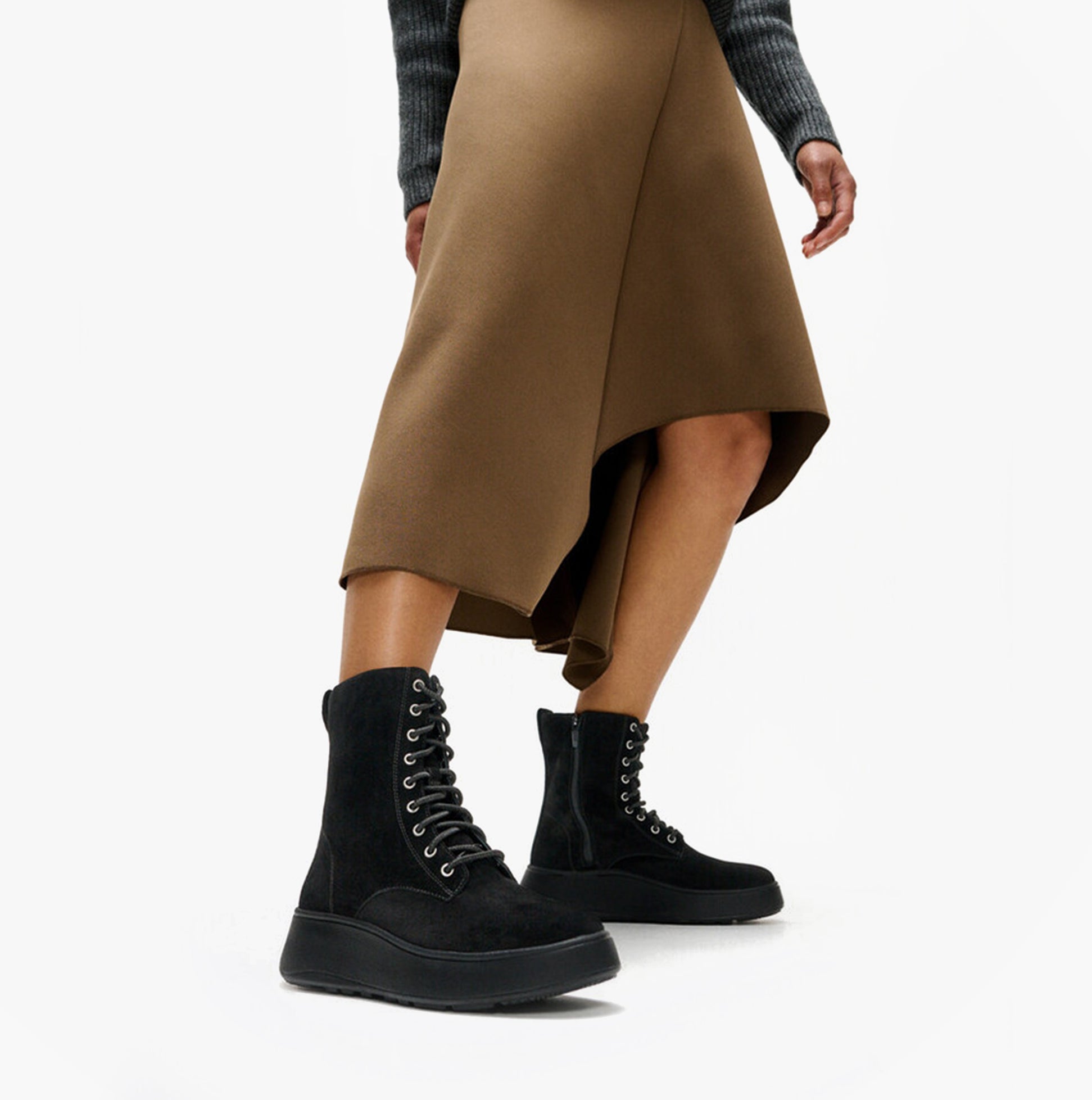 FitFlop F-MODE SUEDE LACE-UP FLATFORM Ladies Ankle Boots All Black side view on model wearing a brown skirt.