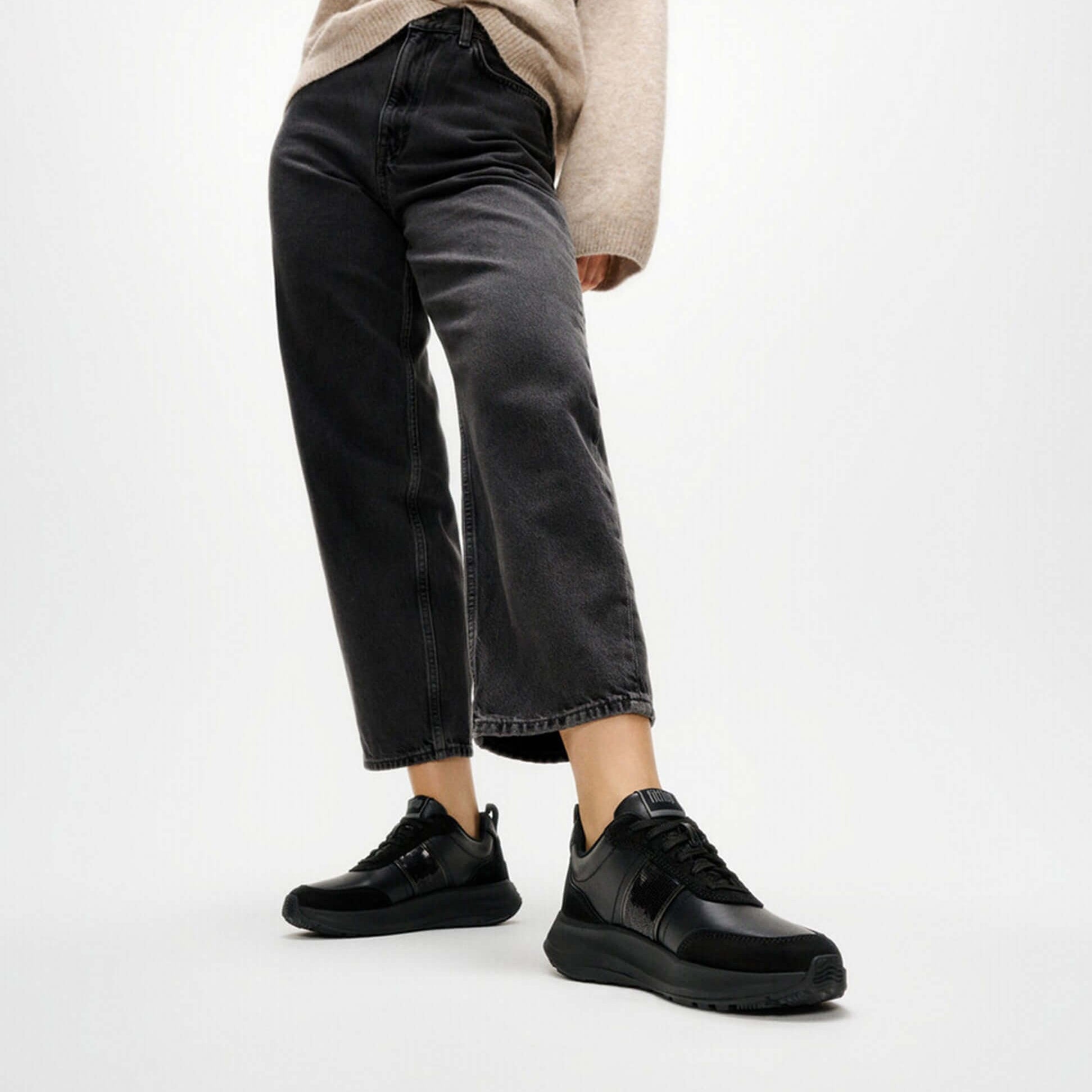 FitFlop F-MODE Womens Leather Trainers Urban Black detail view with model wearing black jeans and trainers.