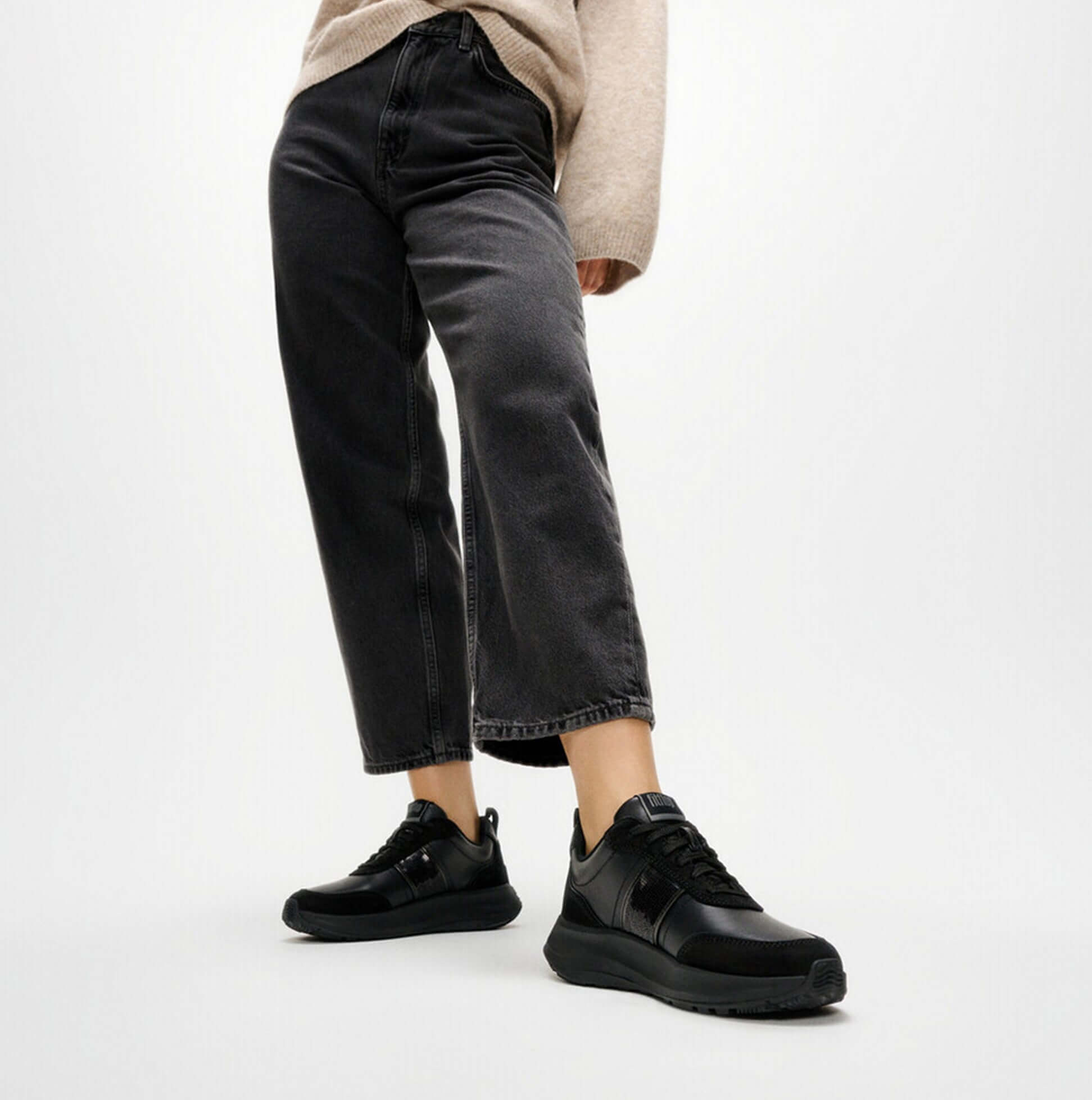 FitFlop F-MODE Womens Leather Trainers Urban Black detail view with model wearing black jeans and trainers.